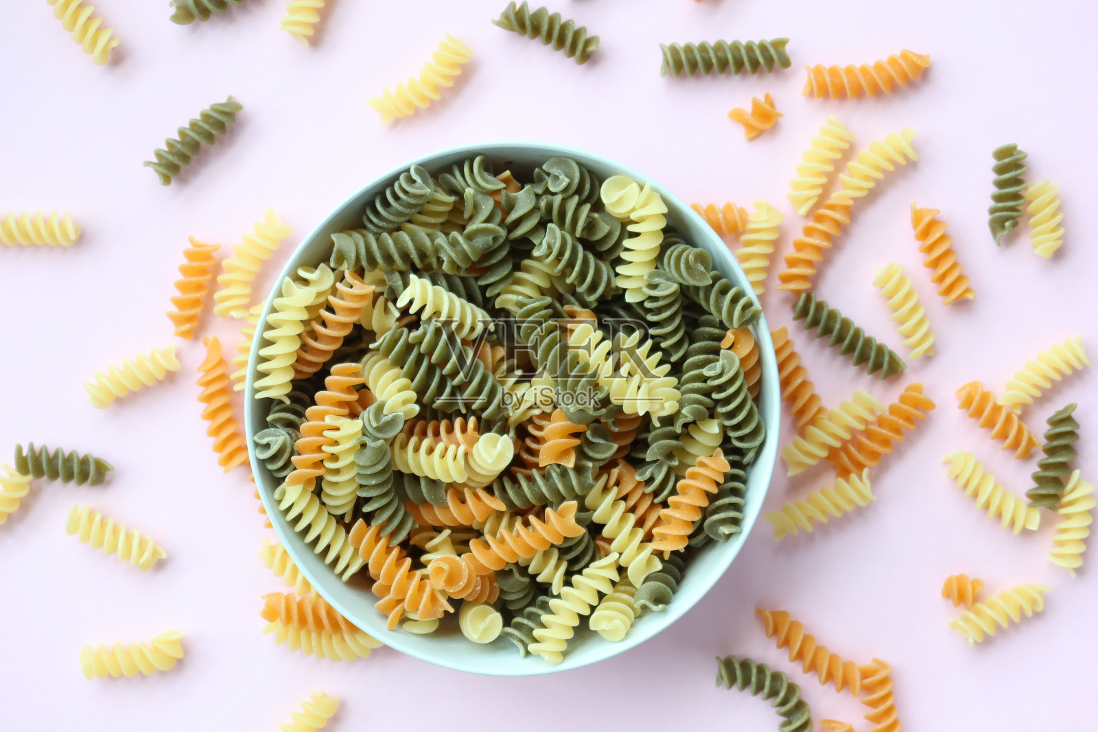 粉色背景上的三色有机通心粉照片摄影图片