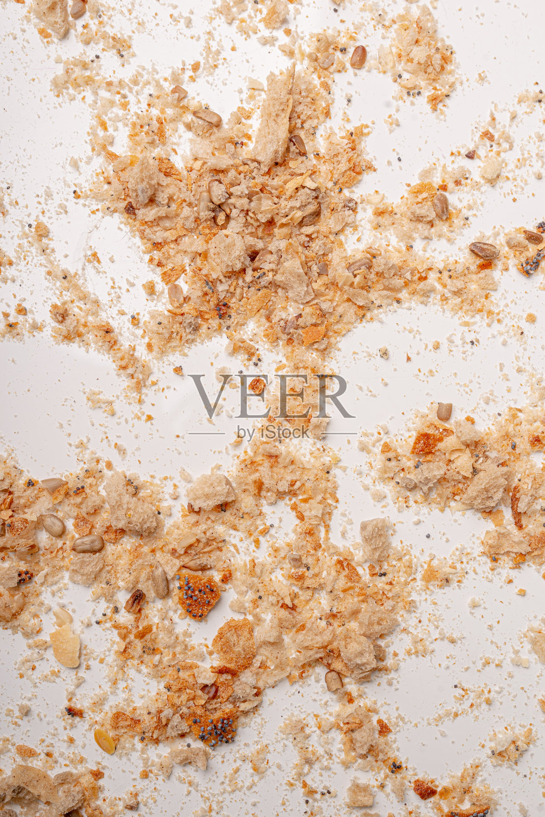 面包屑躺在白色的桌子上。干面包背景。照片摄影图片