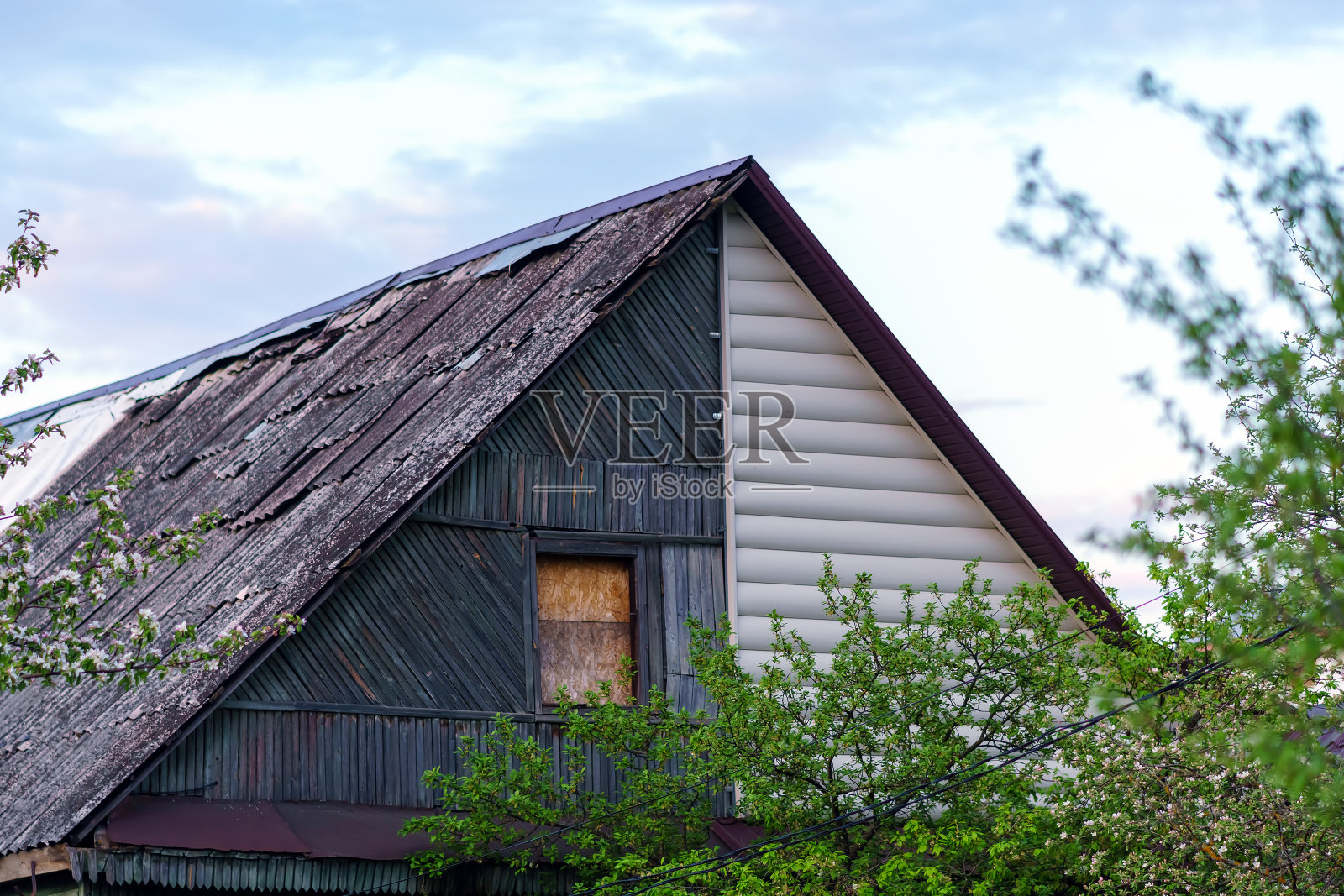 房子的屋顶供两个主人使用，其中一部分被废弃了照片摄影图片