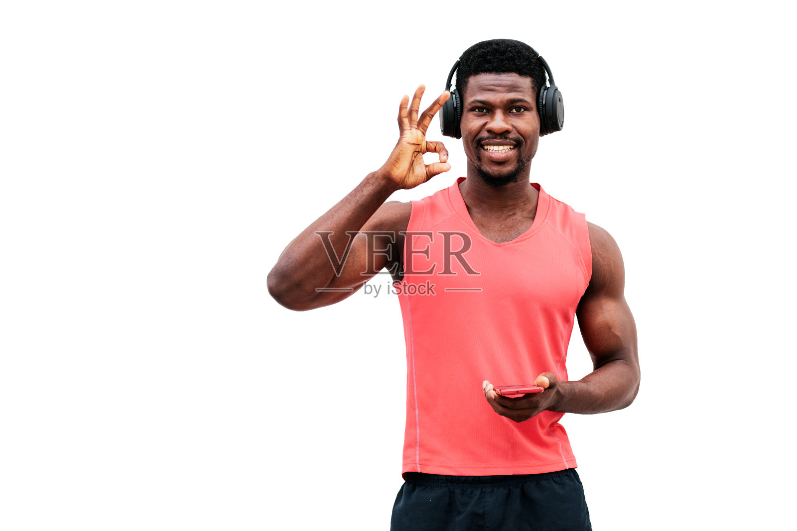 一个非洲裔美国人戴着耳机听音乐，在白色背景上做着ok的手势照片摄影图片