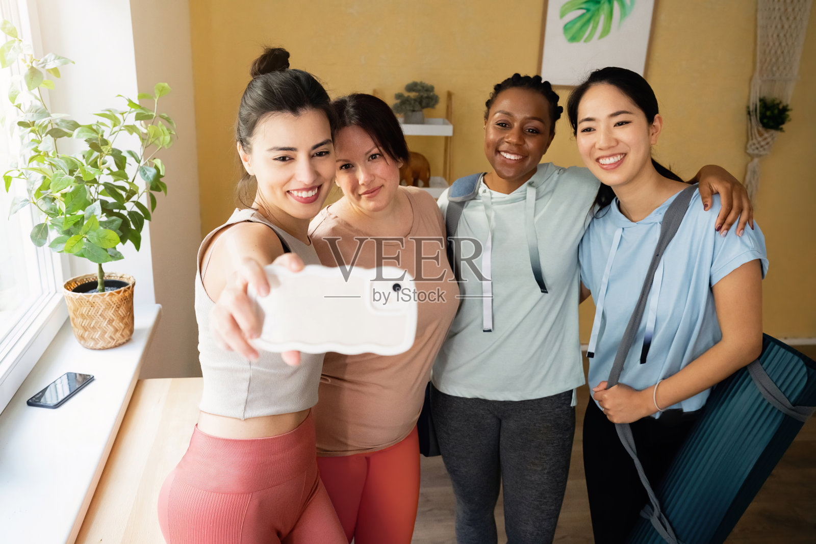 多种族女性在瑜伽课上用手机自拍照片摄影图片