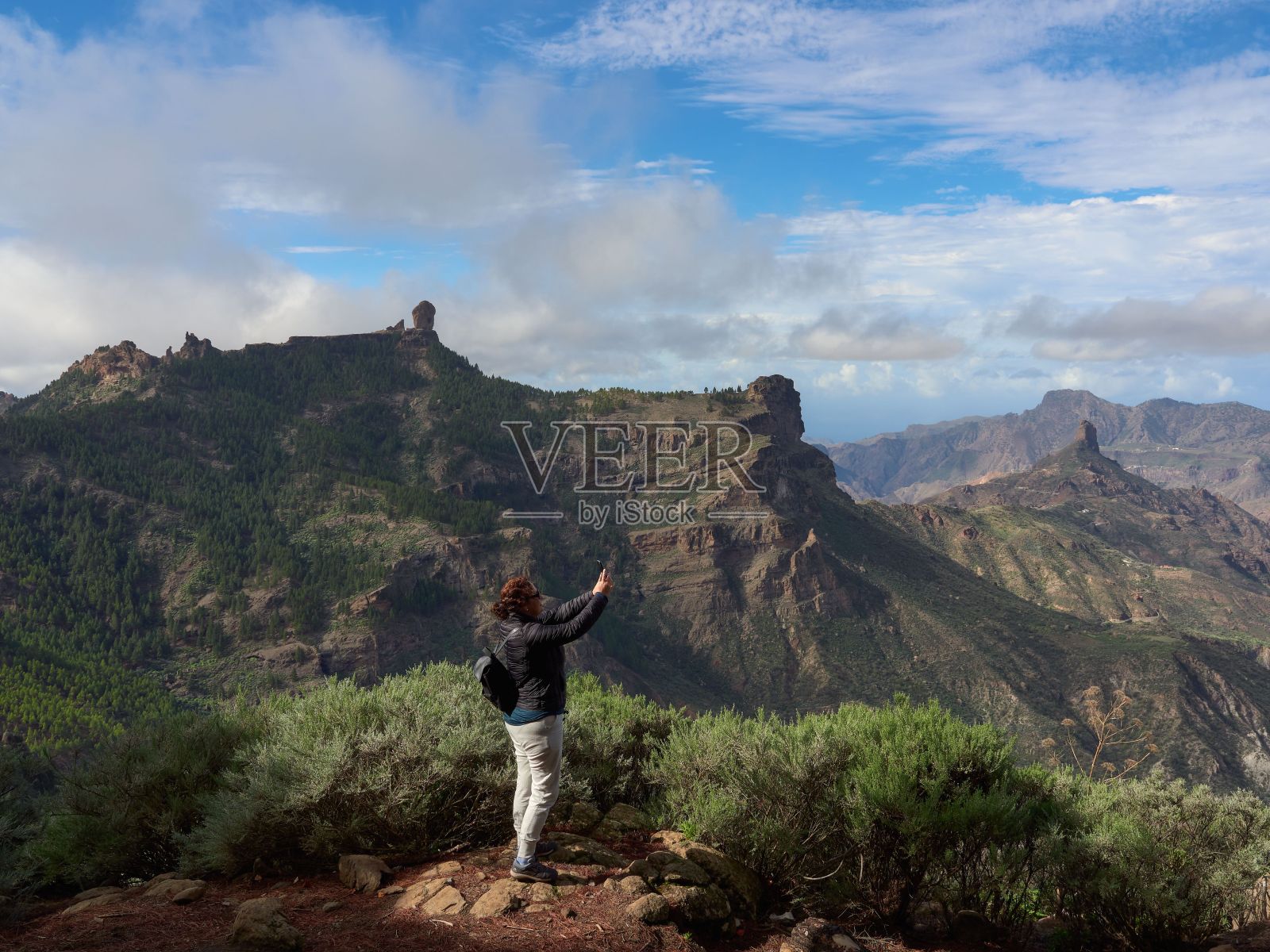 阳光明媚的一天，中年妇女在青山上自拍照片摄影图片