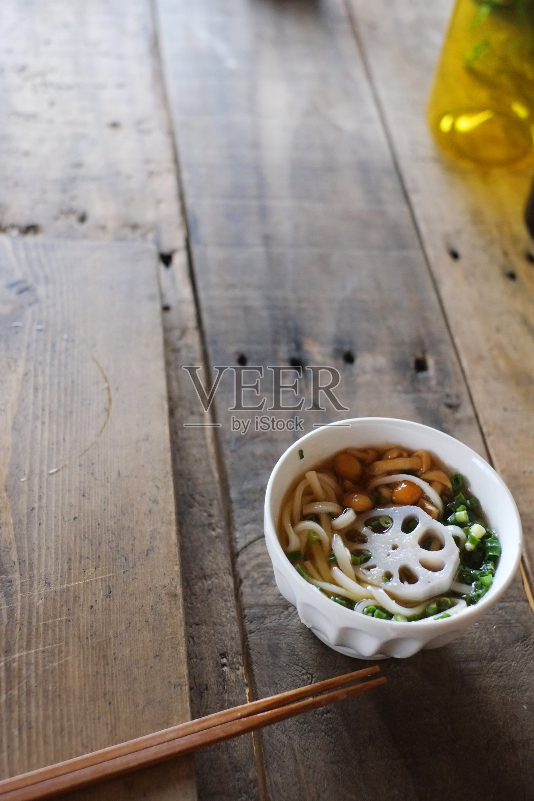 把乌冬面蘸在乌冬汤里。照片摄影图片