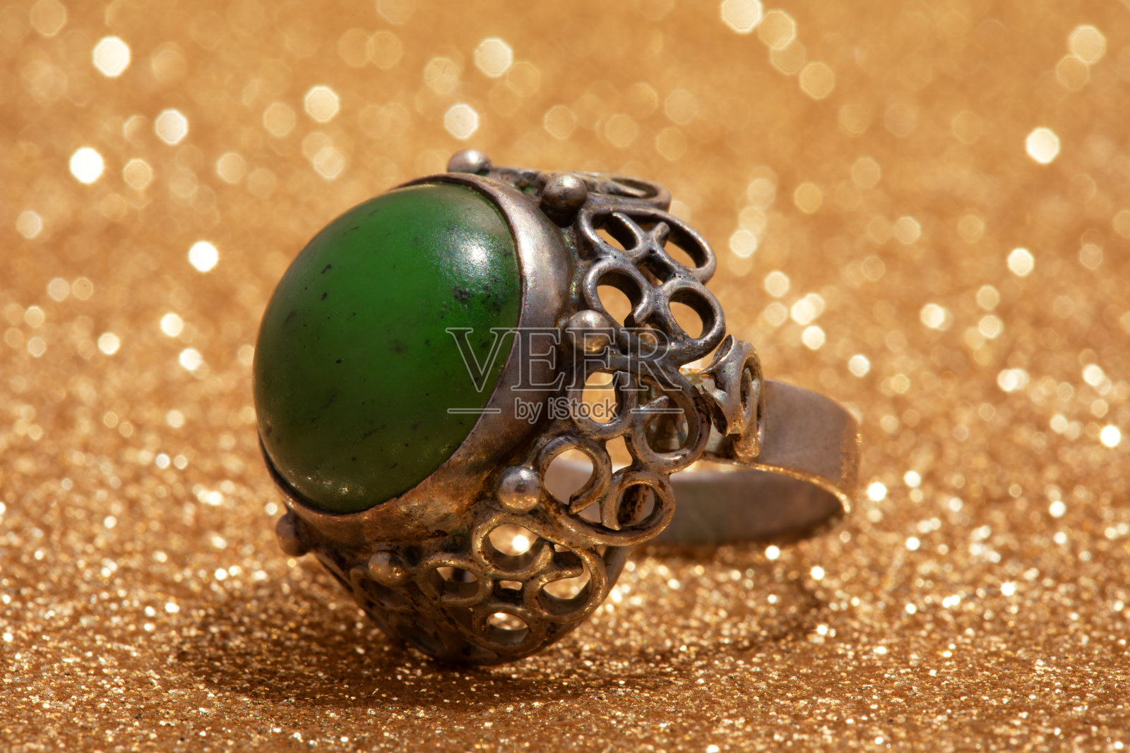 镶着绿石的旧戒指。照片摄影图片