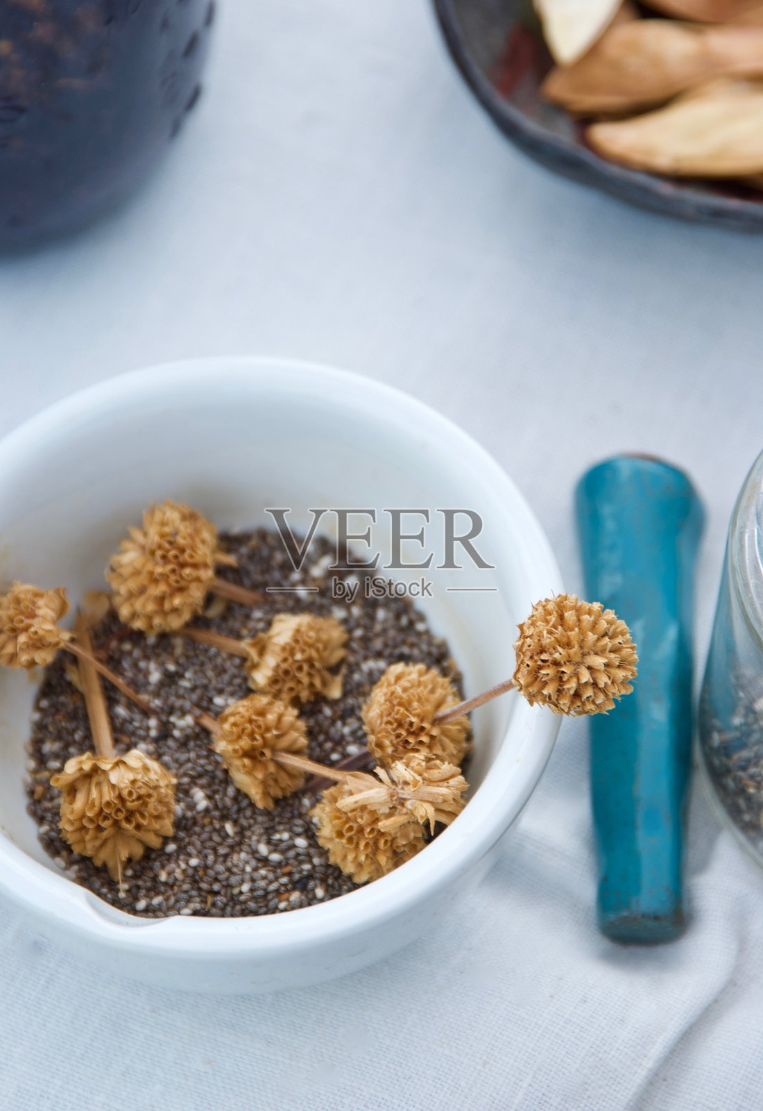 白色桌子上的白色碗里的干沙漠植物品照片摄影图片