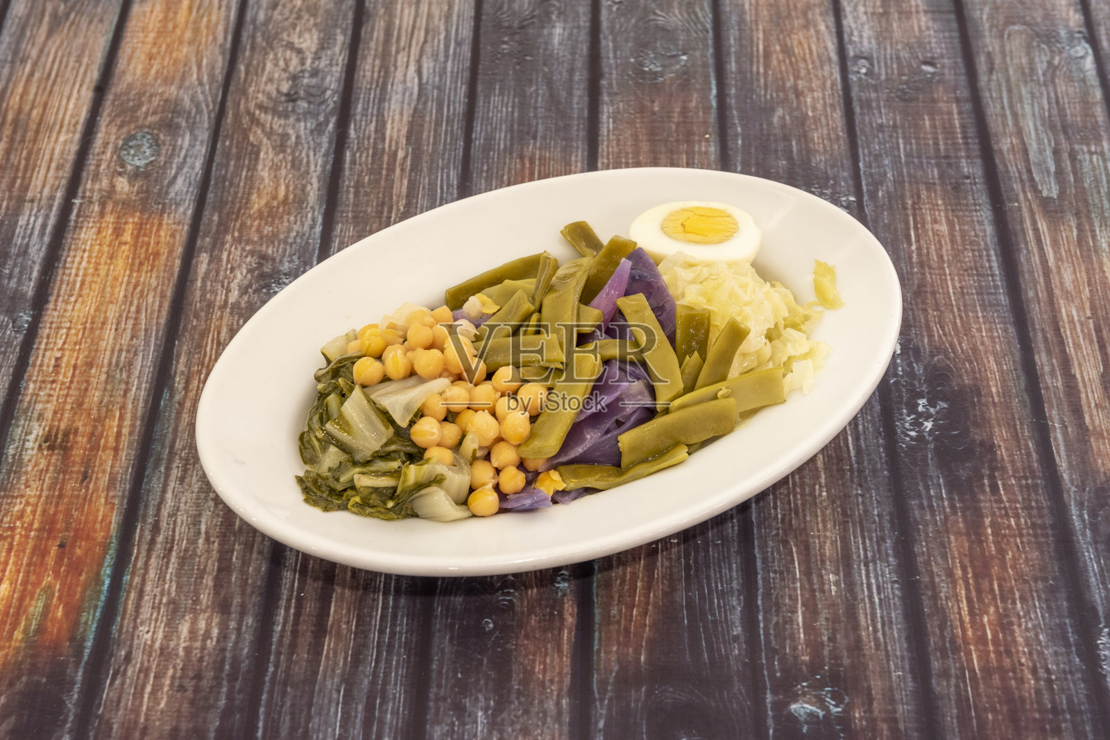 菜园里的蔬菜用油和盐煮过。煮鸡蛋，豆子，鹰嘴豆，卷心菜和瑞士甜菜照片摄影图片