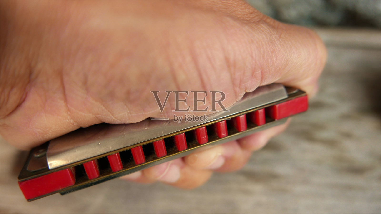 拿口琴的人。用口琴。口琴特写镜头。播放音乐照片摄影图片