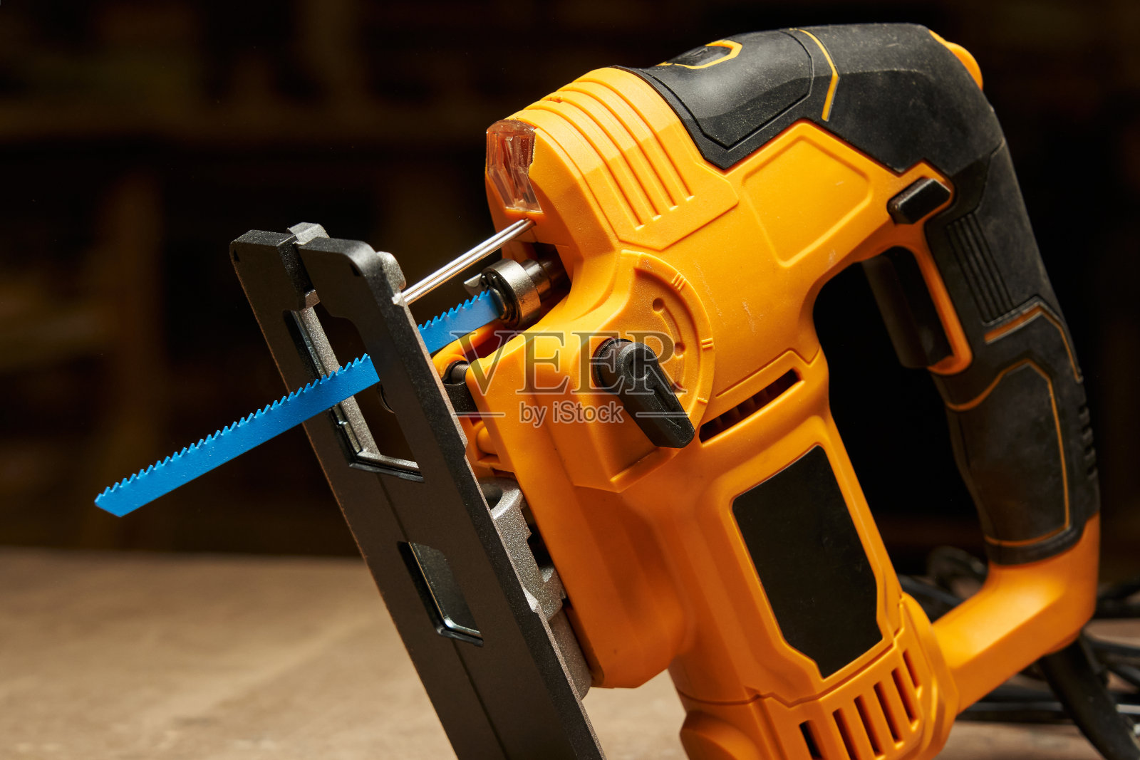 黄黑色电动拼图，蓝色锯片，激光，速度控制器和支撑平台特写照片摄影图片