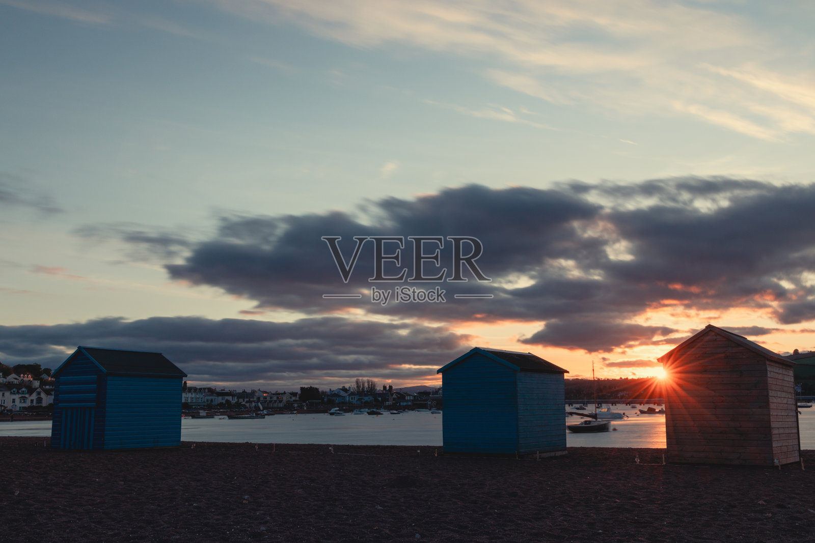 日落时泰格茅斯后海滩上的海滩小屋照片摄影图片