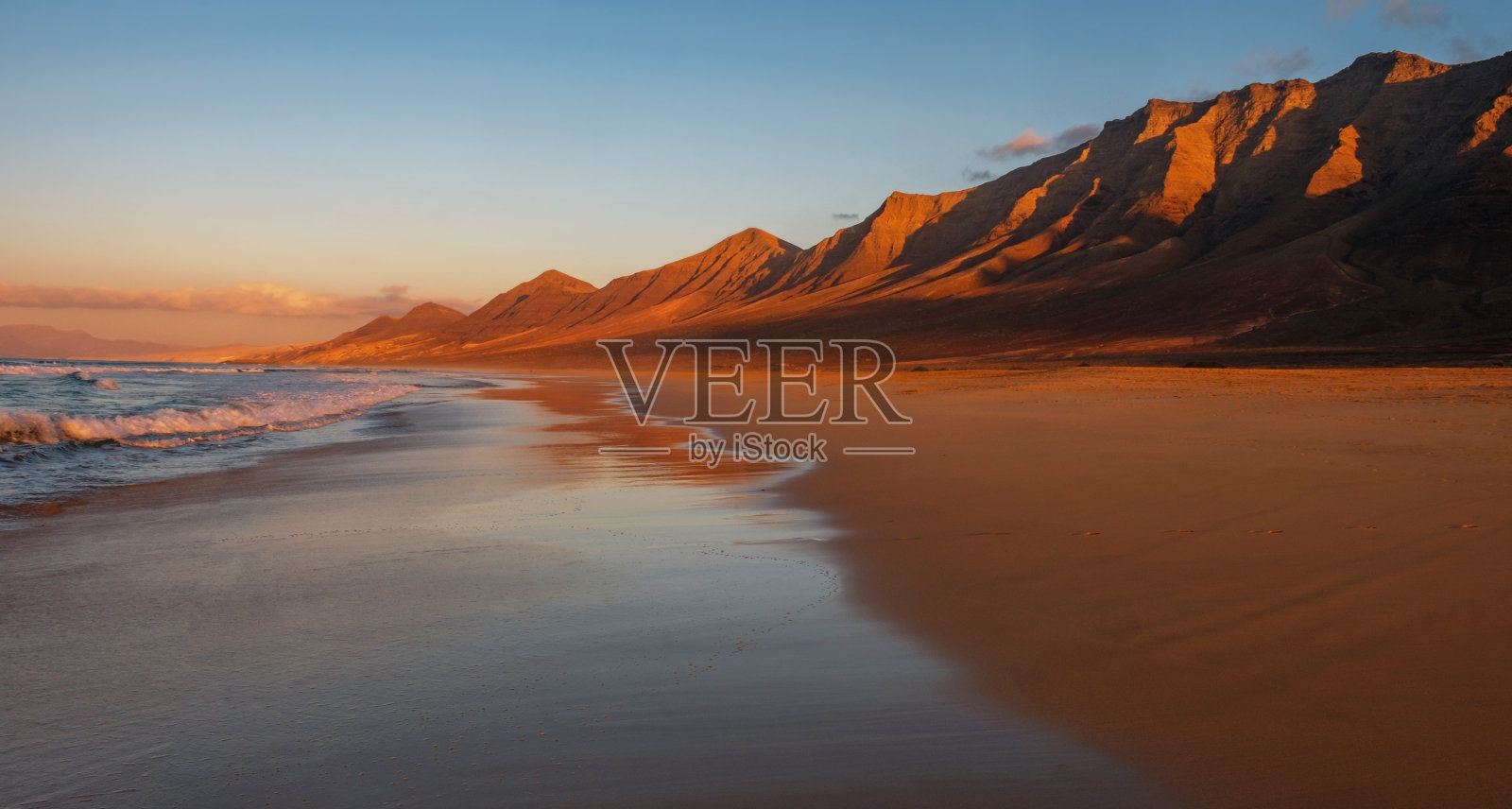 西班牙富埃特文图拉加那利岛日落时的咖啡海滩。照片摄影图片