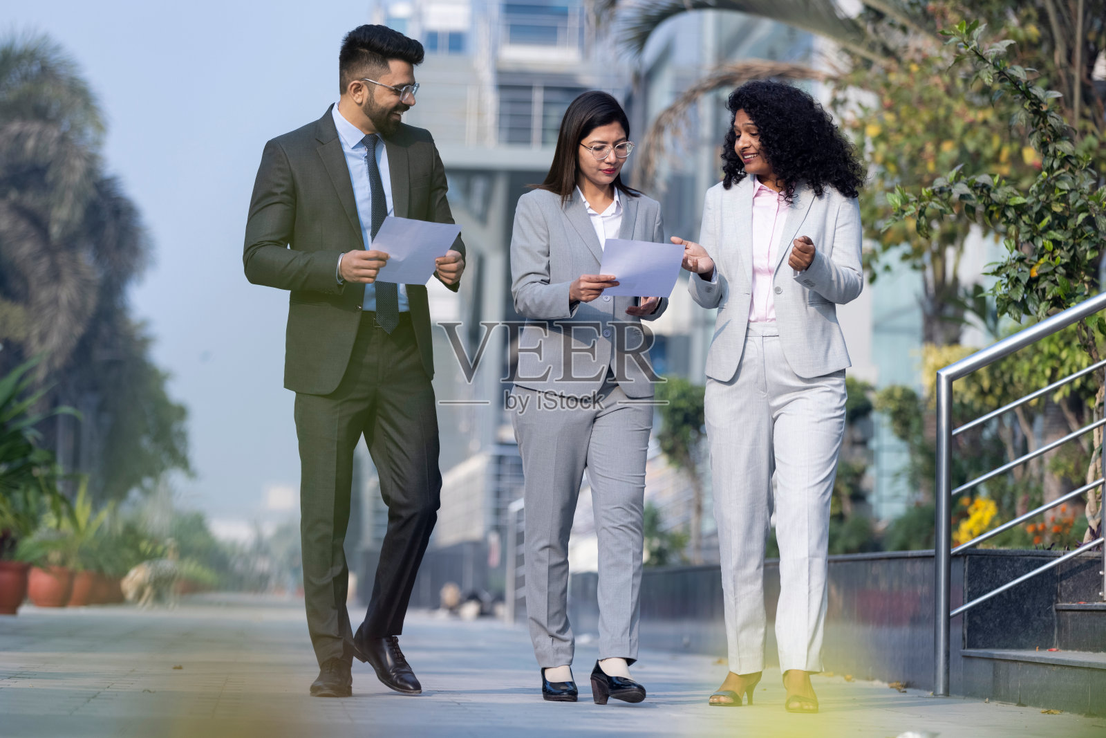 同事们在办公楼外讨论。照片摄影图片