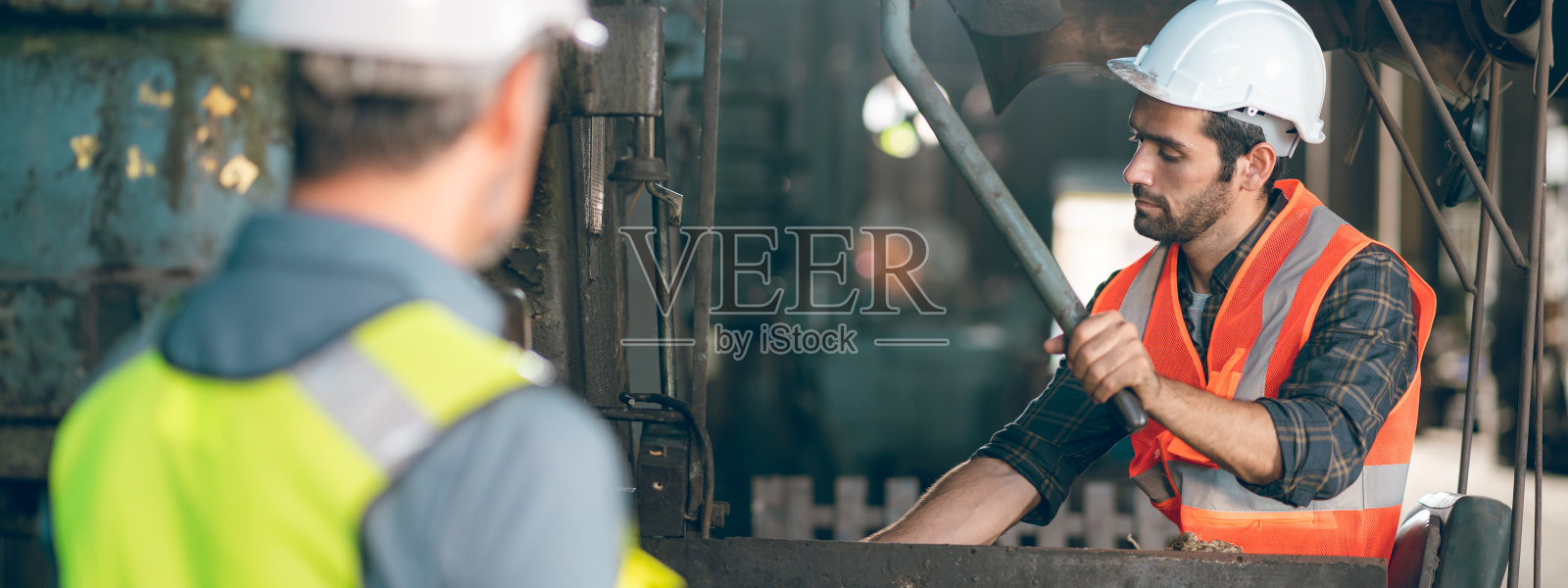 2名土木工程师或专业领班，头戴安全帽，手拿图纸，手拿数码平板电脑，站在工业工厂工作，团队合作理念照片摄影图片