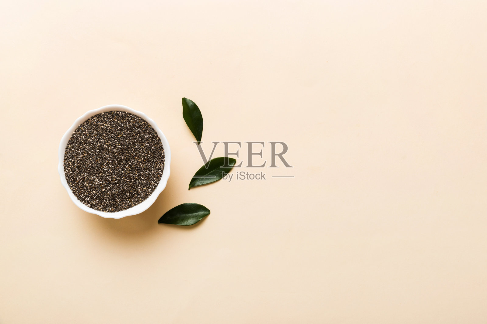 彩色背景碗里的奇亚籽。小碗里的健康鼠尾草。健康的超级食物照片摄影图片