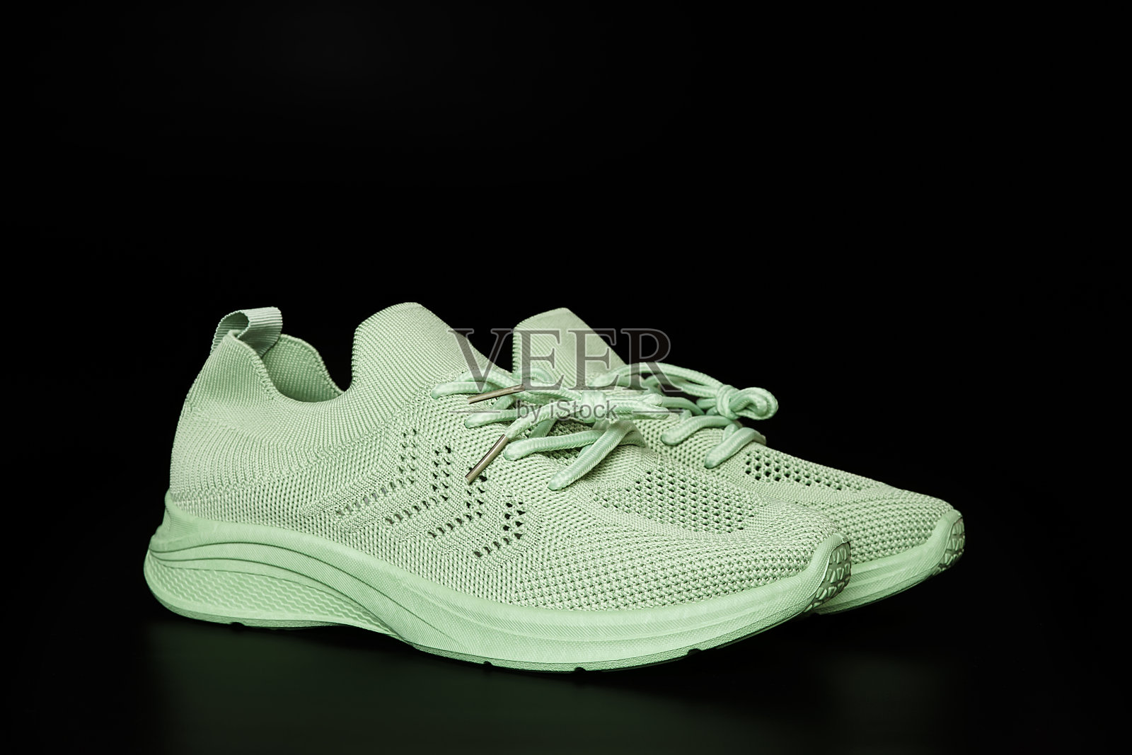 一双黑色背景的绿色运动鞋照片摄影图片