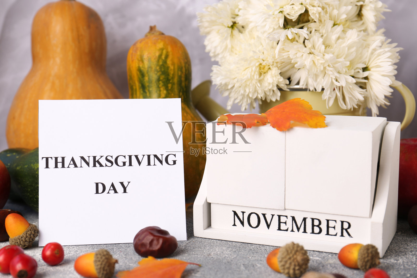 感恩节是十一月的第四个星期四庆祝的节日。秋天的构图与木块日历和纸卡在灰色的桌子上照片摄影图片