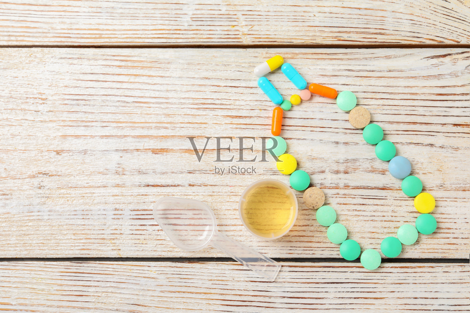 药瓶，糖浆量杯，白色木桌，平放，留出文字空间。感冒药照片摄影图片