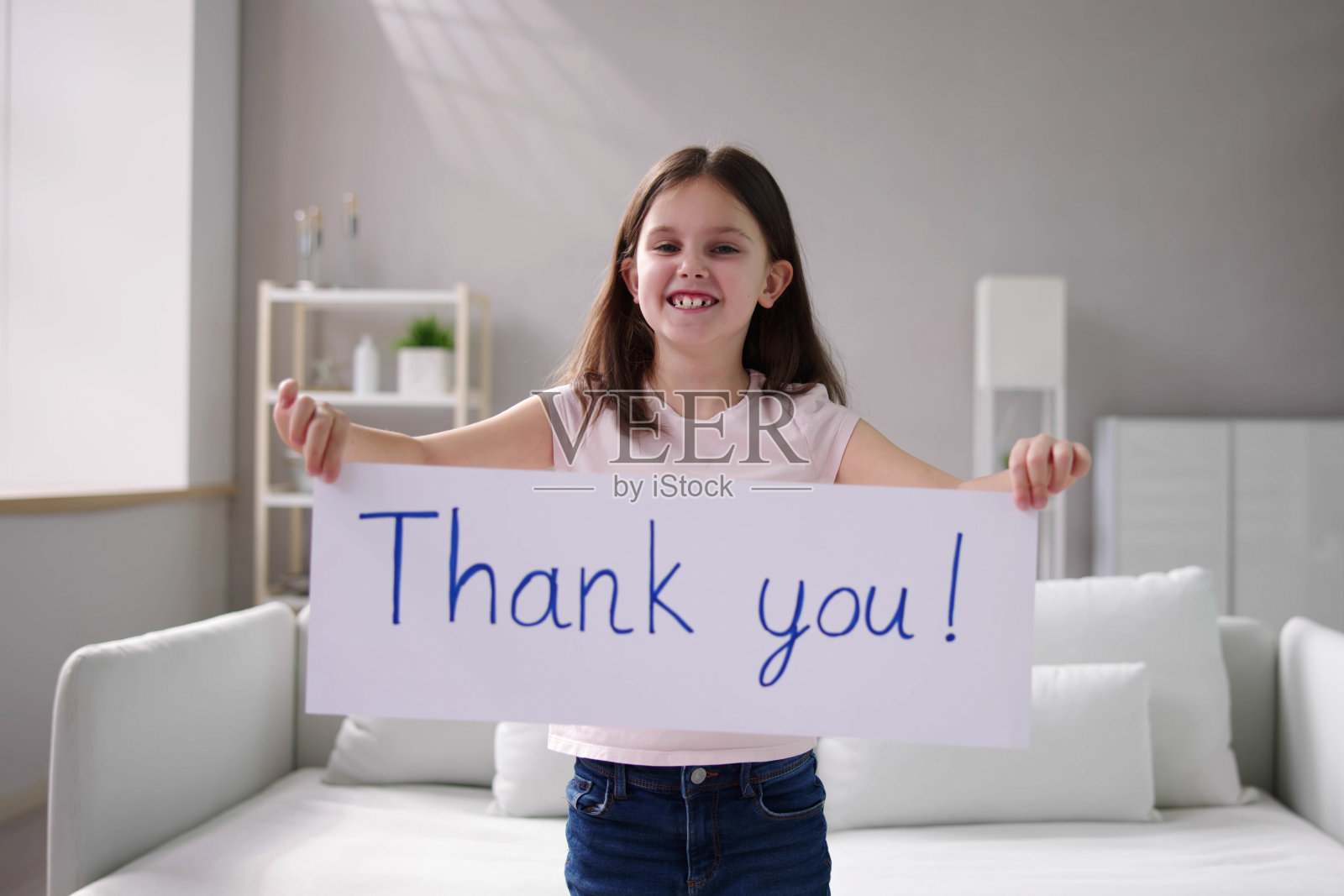 微笑的女孩举着感谢白人的牌子照片摄影图片