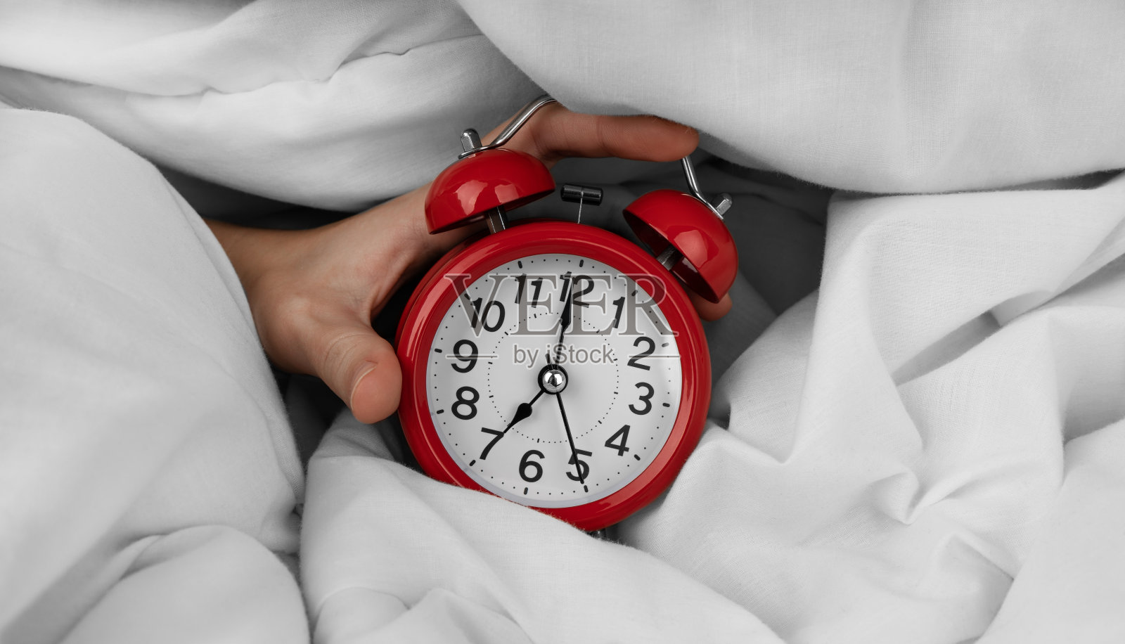 女人的手在关掉床上的红色闹钟照片摄影图片