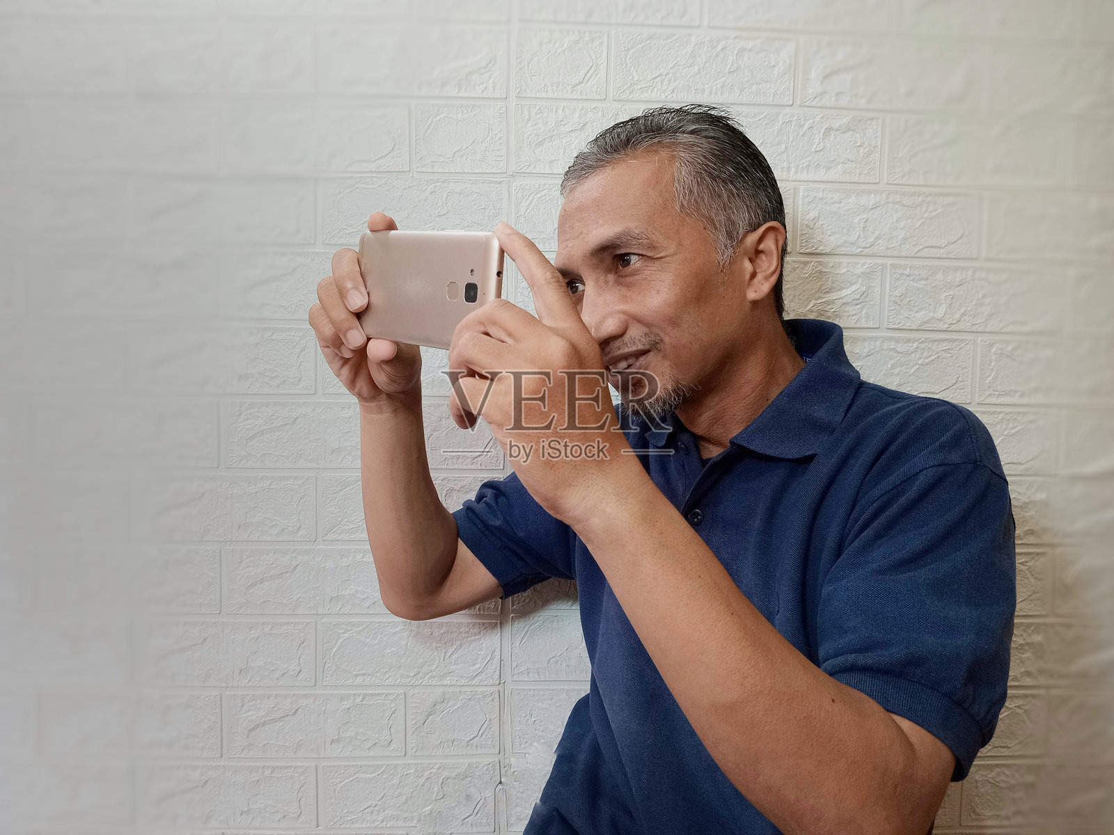 一个人的孤立形象正在用智能手机拍照。照片摄影图片