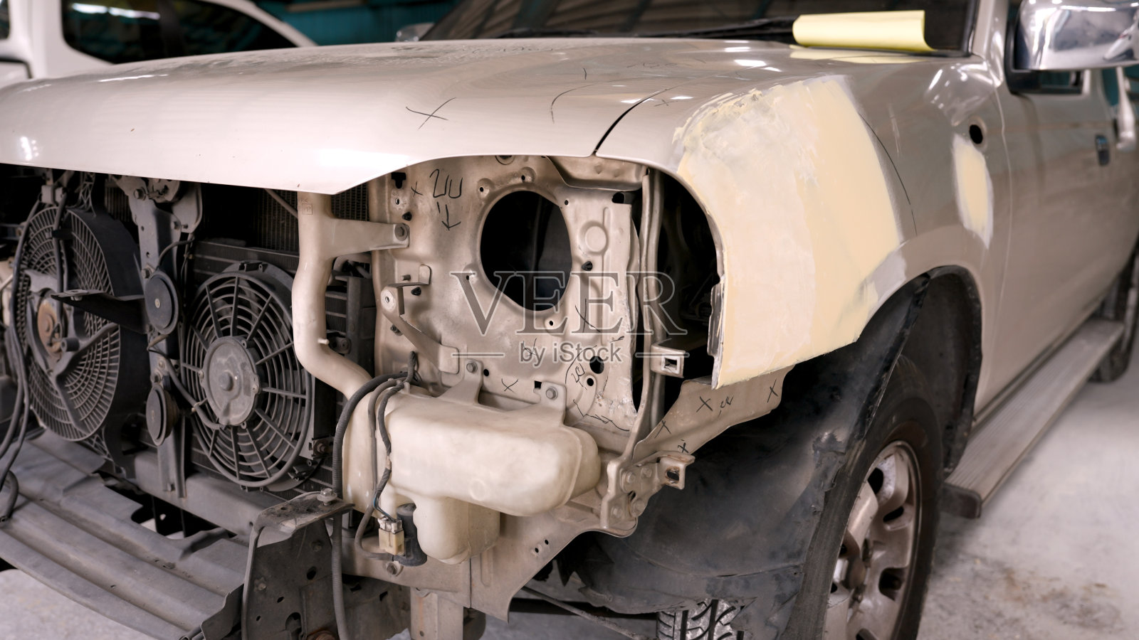 小货车前保险杠意外损坏停在一家大型汽车修理厂等待修理。该法案规定了由专业技术人员修复汽车车身漆以恢复正常使用的标准照片摄影图片