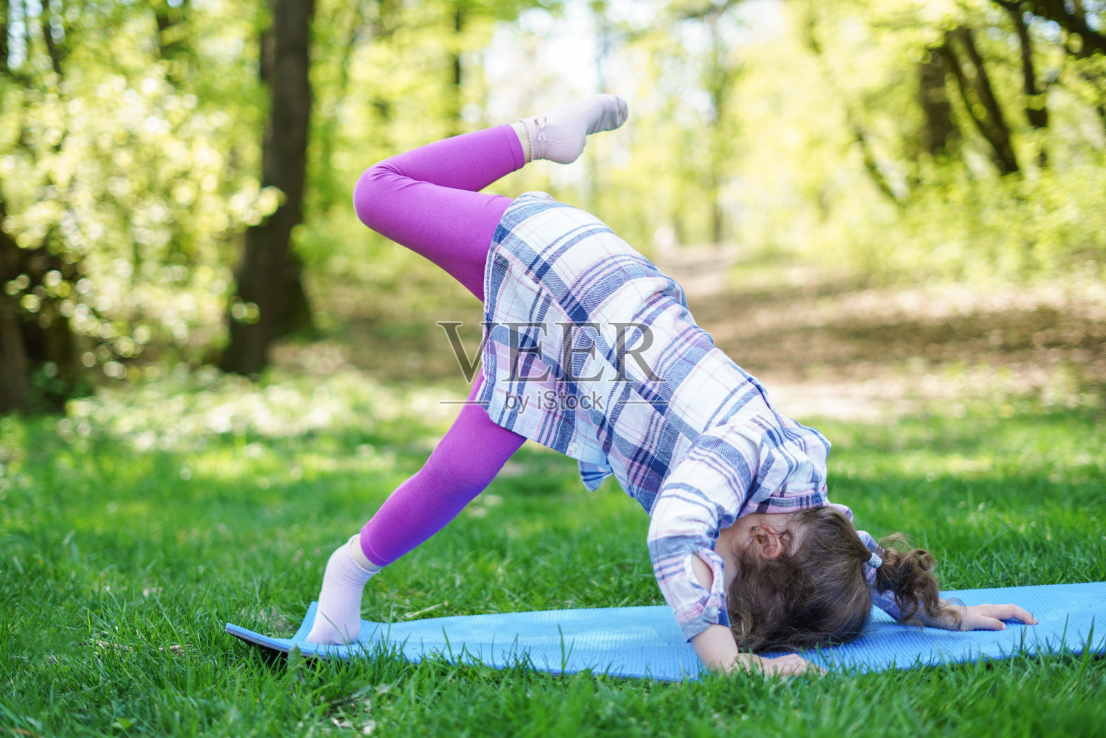 小女孩在公园里做瑜伽，健康的生活方式照片摄影图片
