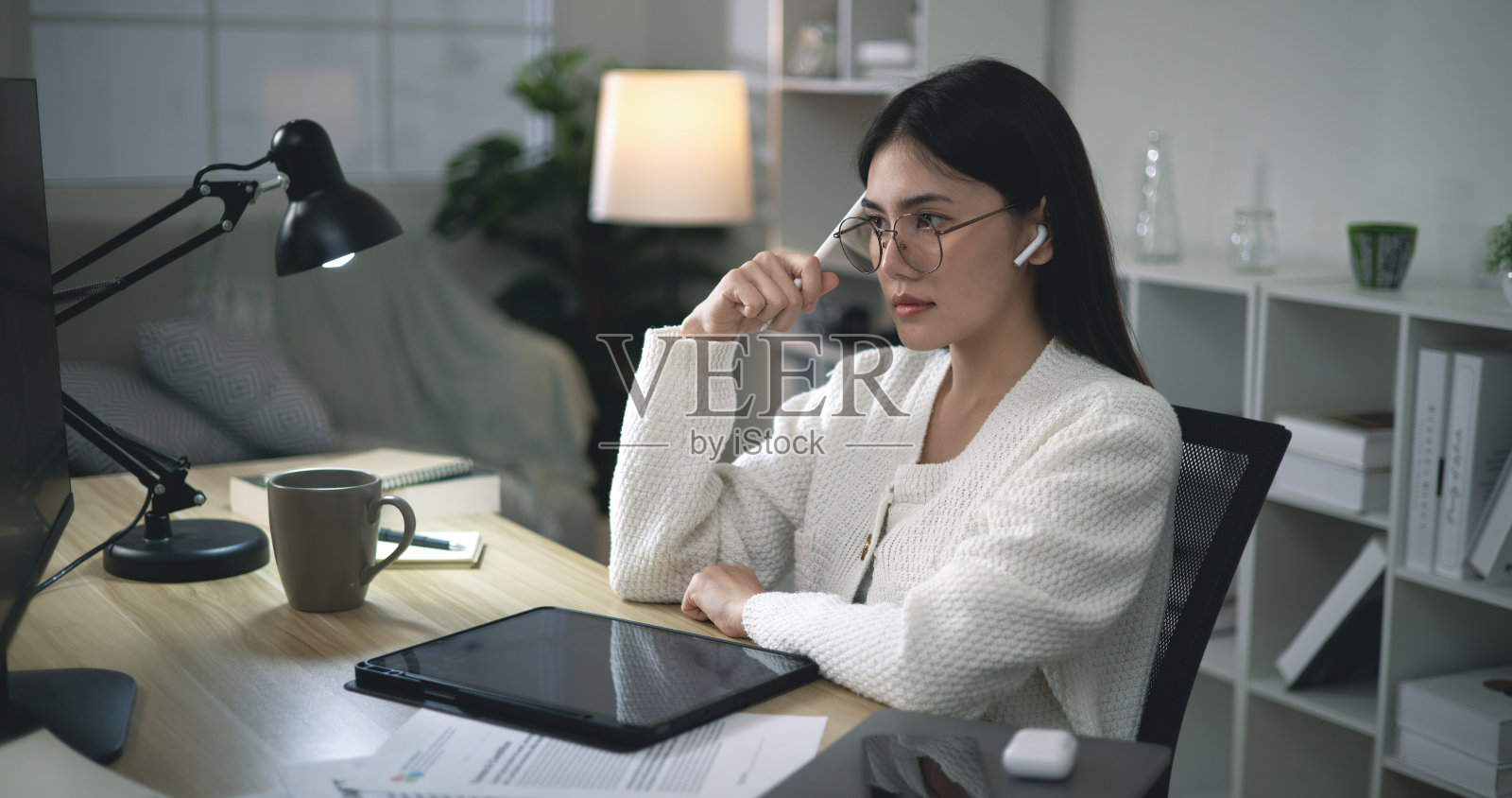 戴眼镜的年轻女子在家使用笔记本电脑进行在线学习照片摄影图片