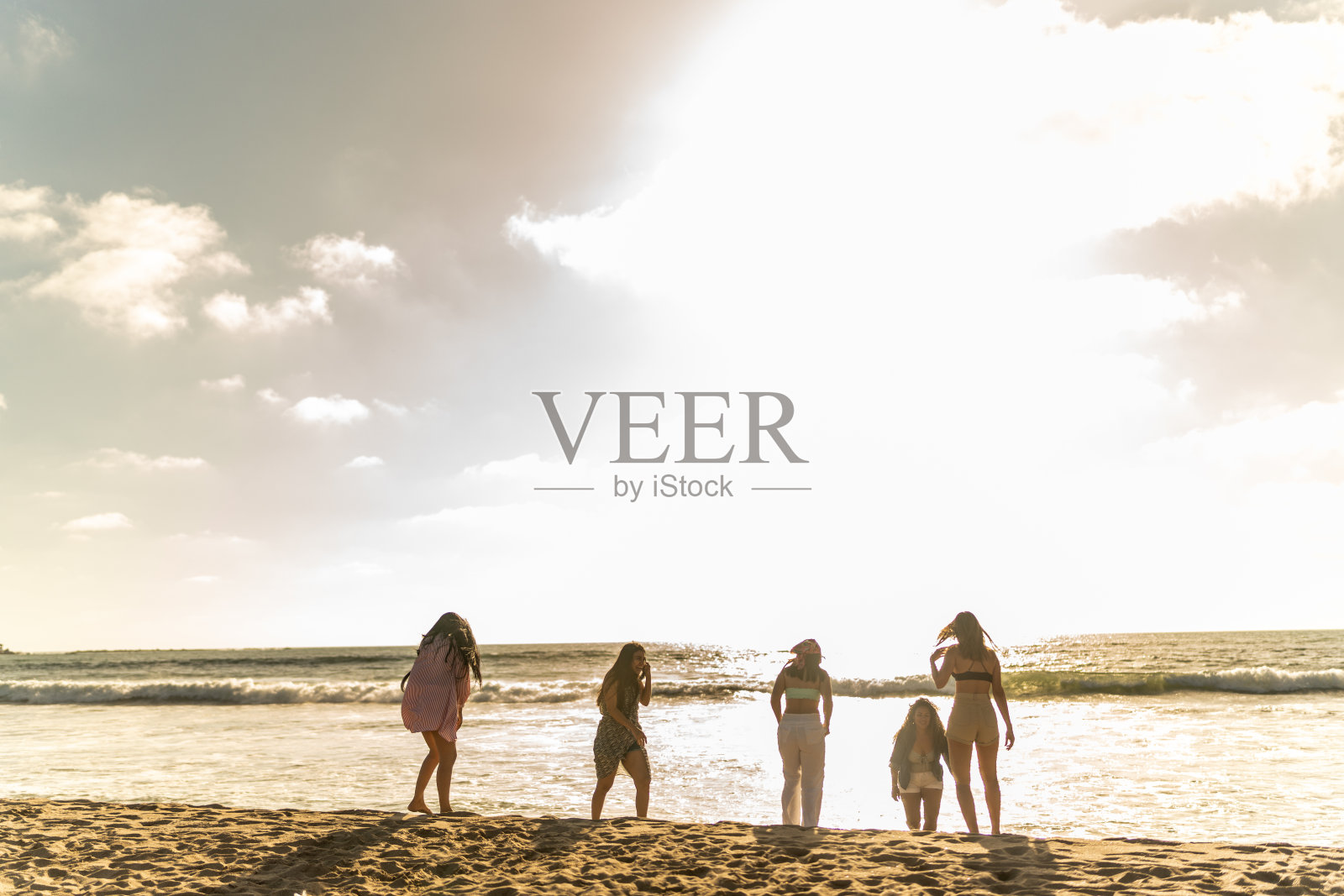 女性朋友在沙滩上散步时玩得很开心照片摄影图片