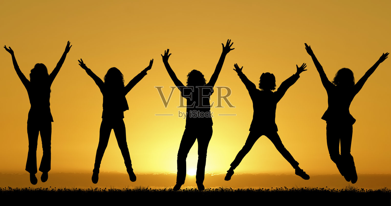 快乐的朋友在夕阳的背景下跳跃照片摄影图片