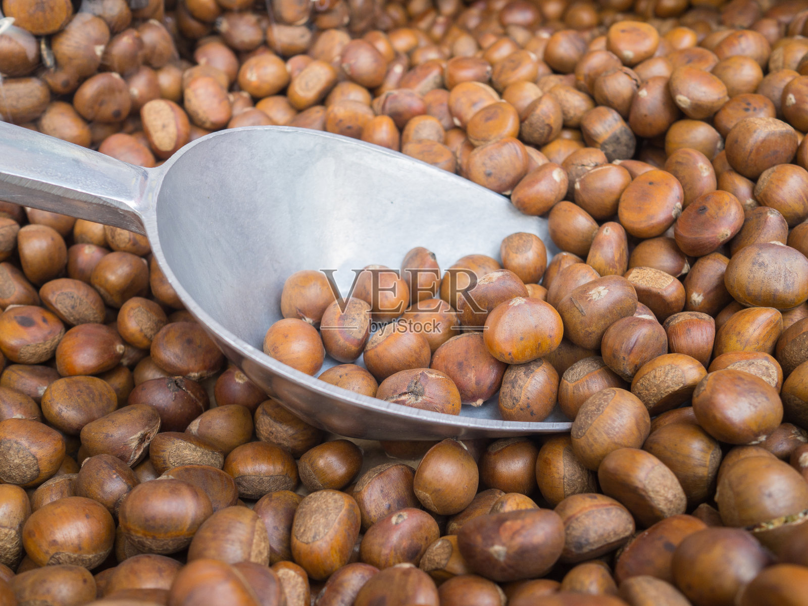 在市场上烘烤出售的栗子。照片摄影图片