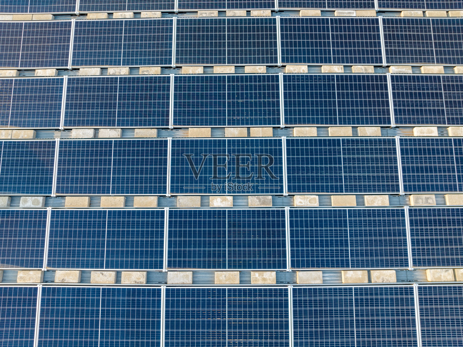 航拍太阳能板安装在平坦的商业、工业屋顶上，用混凝土砌块。照片摄影图片