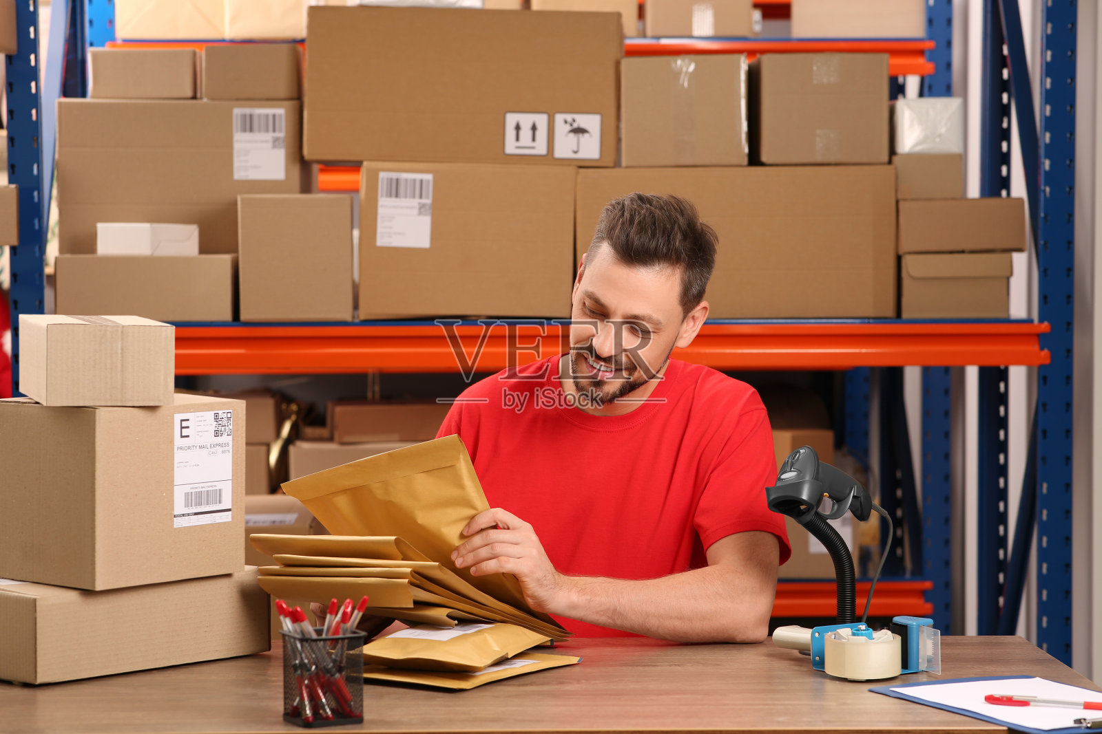 邮局职员在室内柜台拿着胶袋照片摄影图片