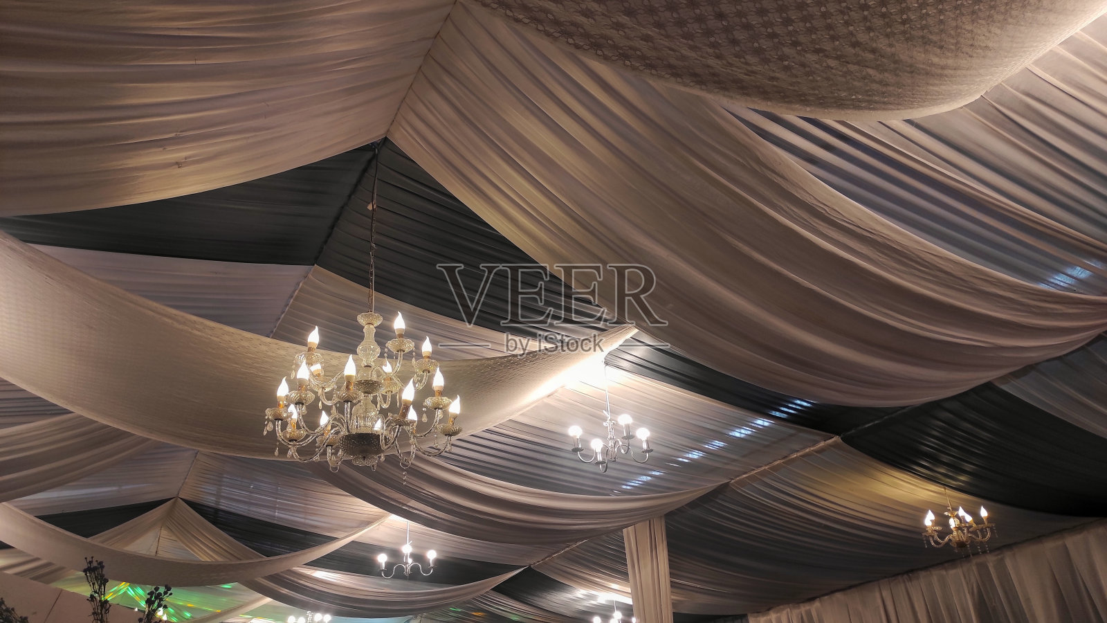 黄灯的枝形吊灯旁边的白色灯在天花板上浅灰色的装饰在婚礼聚会照片摄影图片