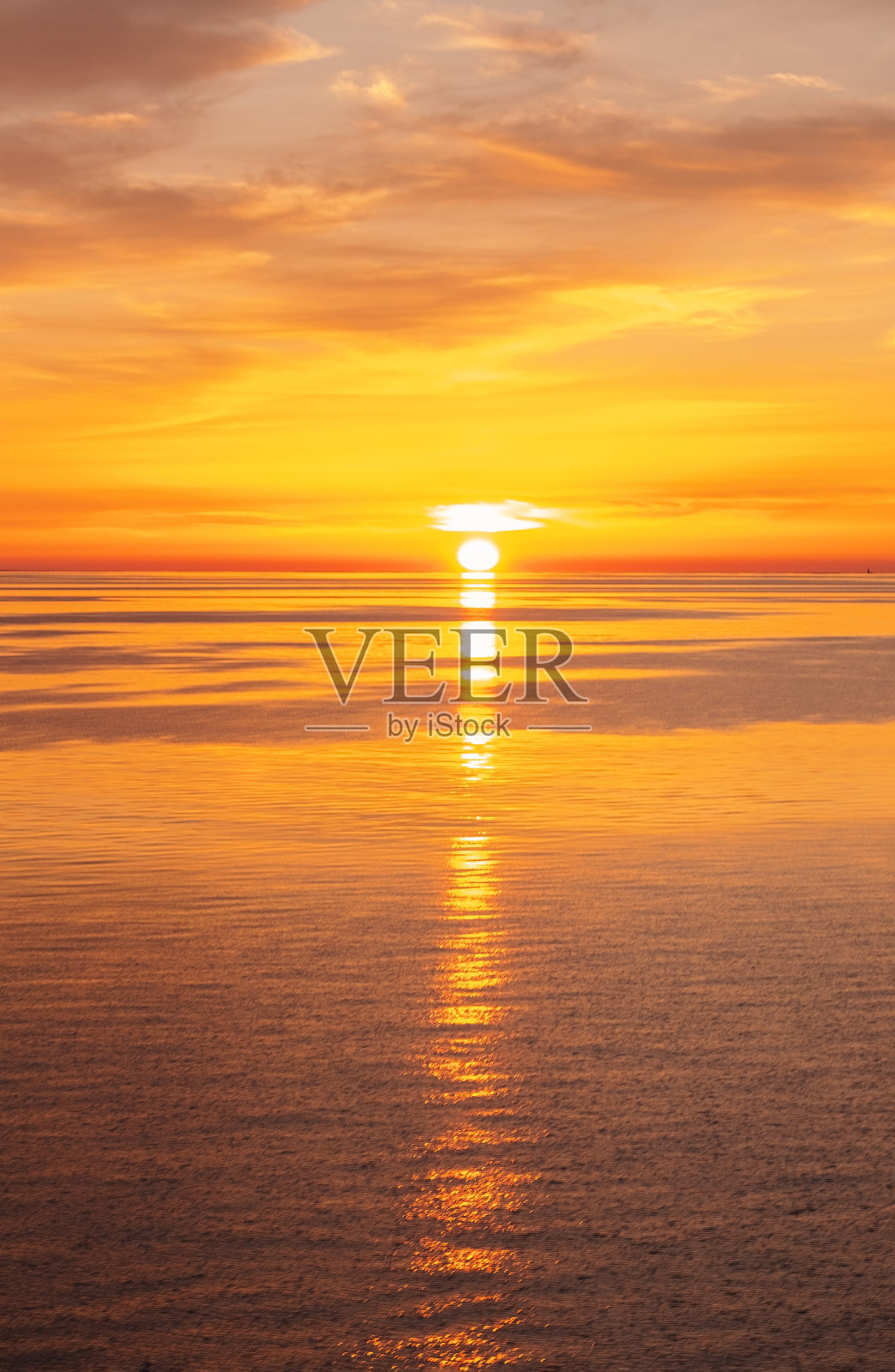 明亮的橙色日落在海上。云和地平线在海上相接。照片摄影图片