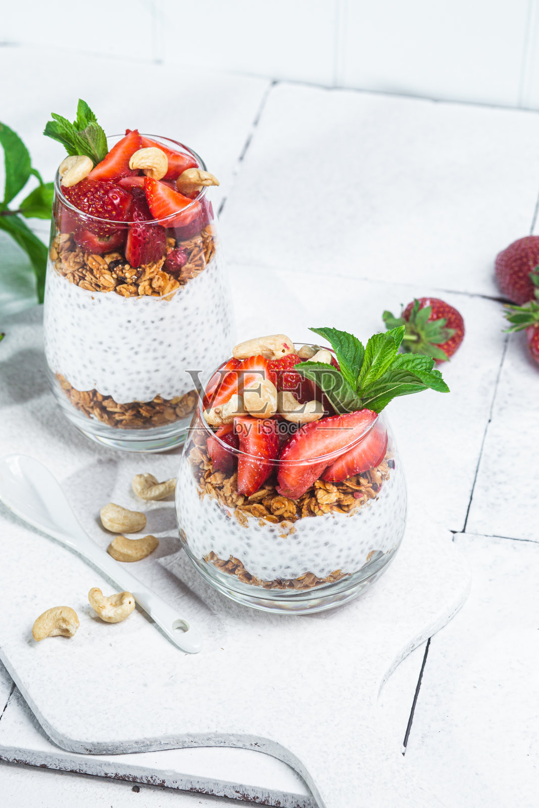 白色背景玻璃杯装酸奶奇亚籽草莓燕麦照片摄影图片