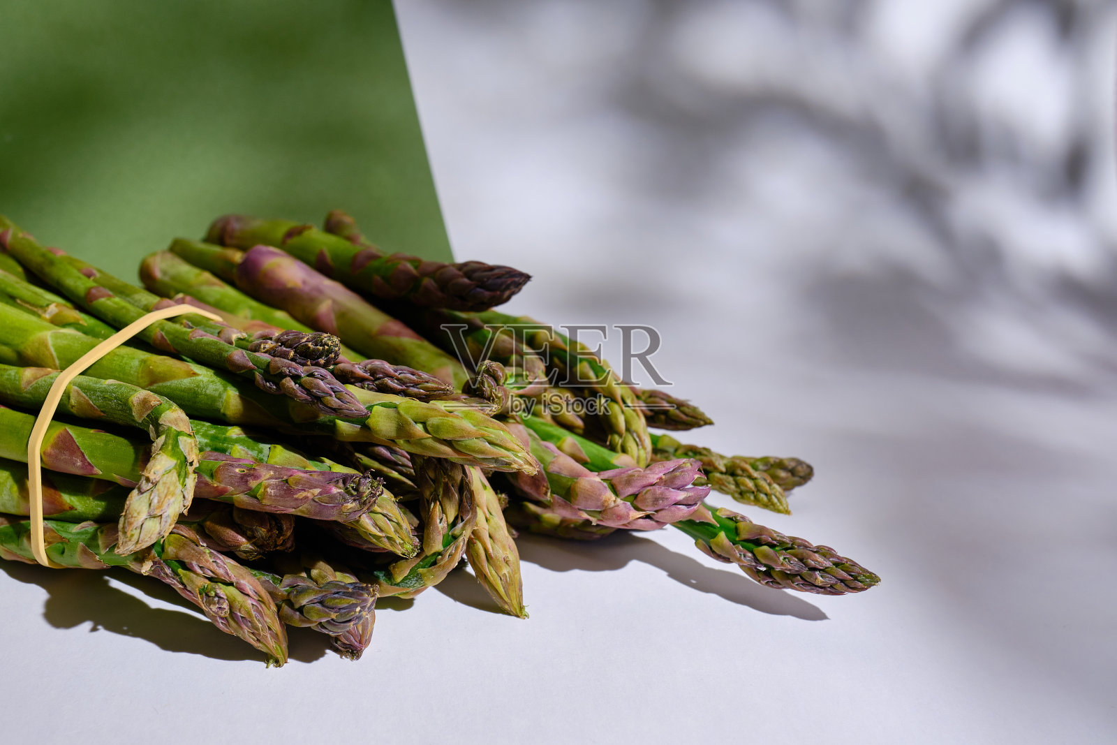 绿色的芦笋在浅色的背景上。一束成熟的新鲜芦笋。健康的有机食品。在家做饭。天然维生素，食品原料。精心挑选的生物芦笋照片摄影图片