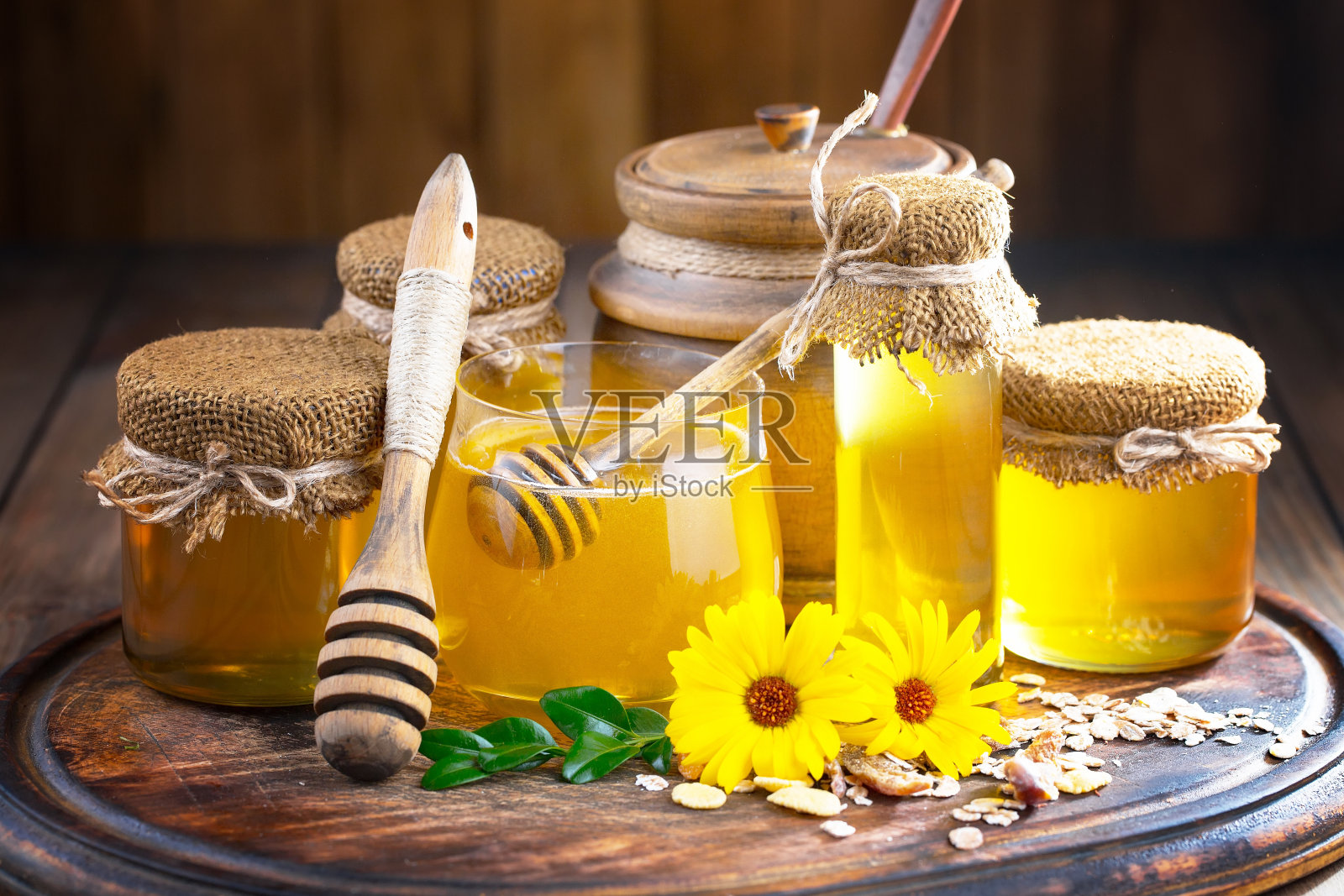 蜂蜜配黄花，木制背景。照片摄影图片