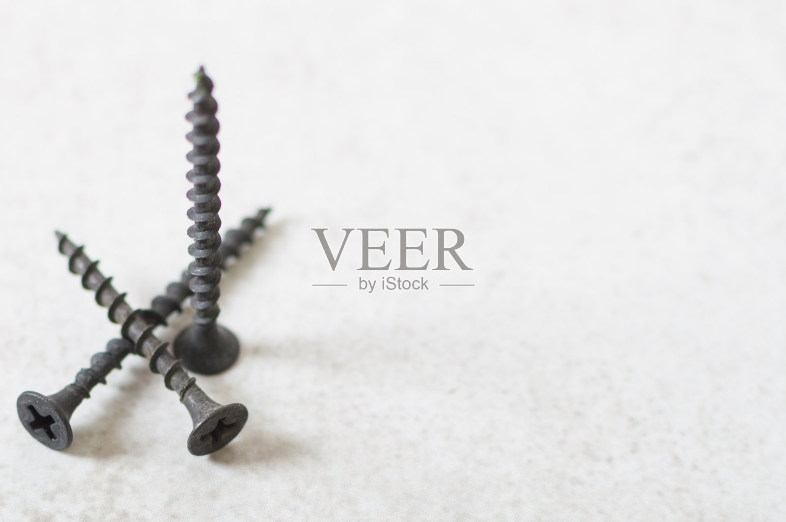 桌子上有三个自攻螺钉。男人的爱好。建筑工具照片摄影图片