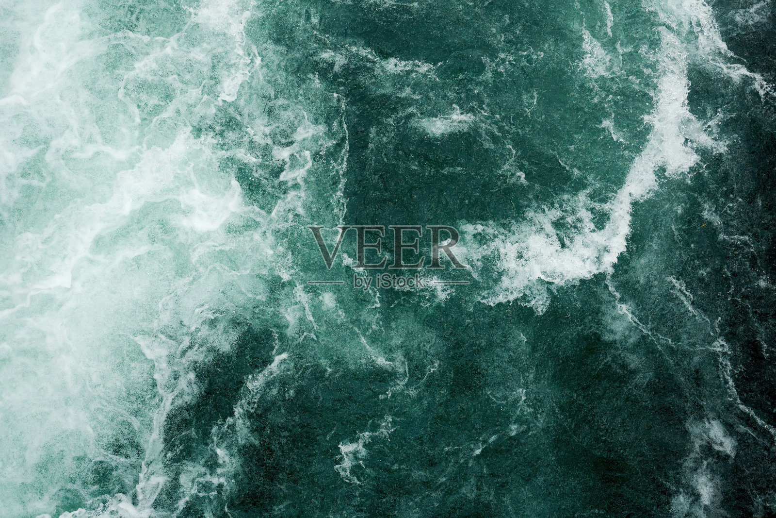 蓝色暴风雨水面的图案，白色的波浪和飞溅照片摄影图片