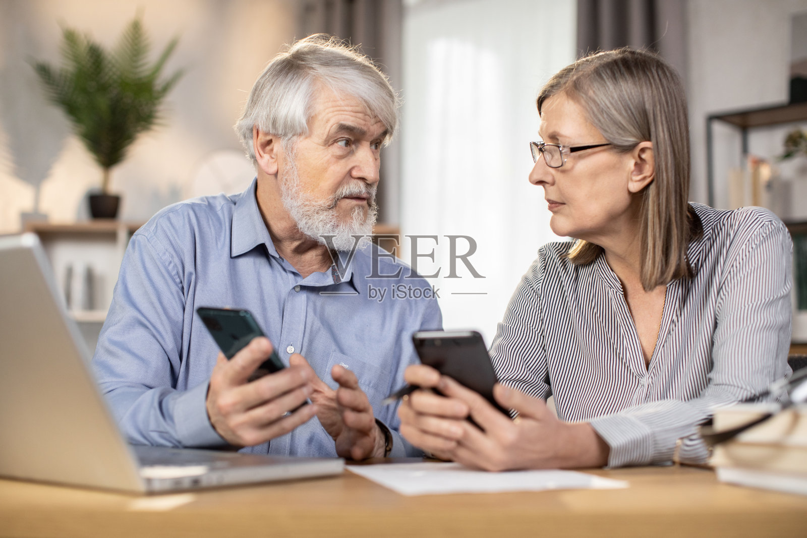 拿着手机的商人在家里互相看着对方照片摄影图片