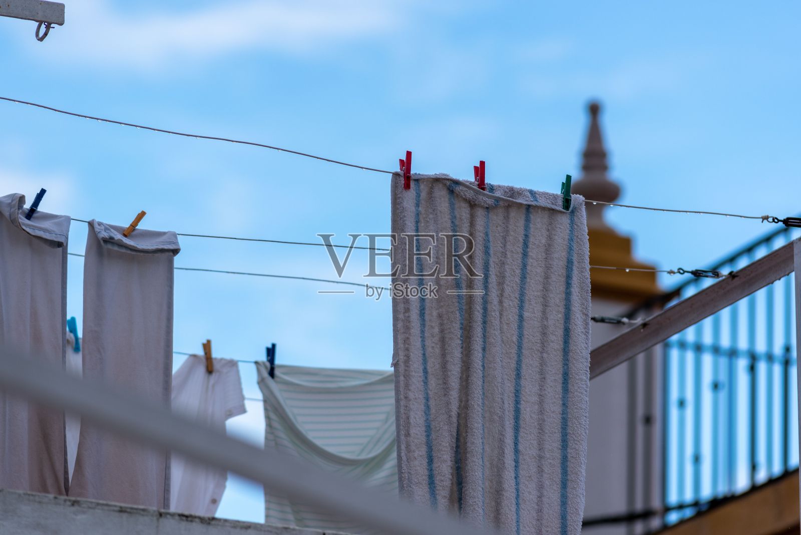 在城市中，毛巾挂在晾衣绳上，背景是各种建筑照片摄影图片