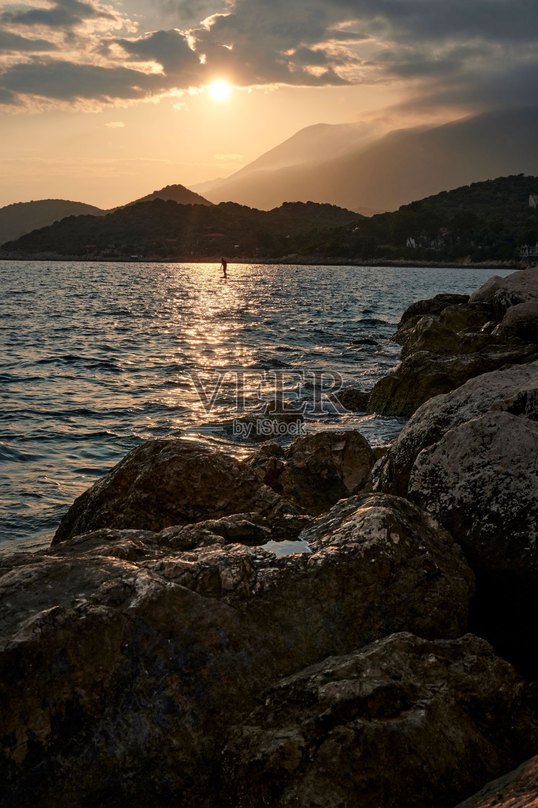 风景优美的日落在一个宁静的水体与岩石在前景。ka,土耳其。照片摄影图片