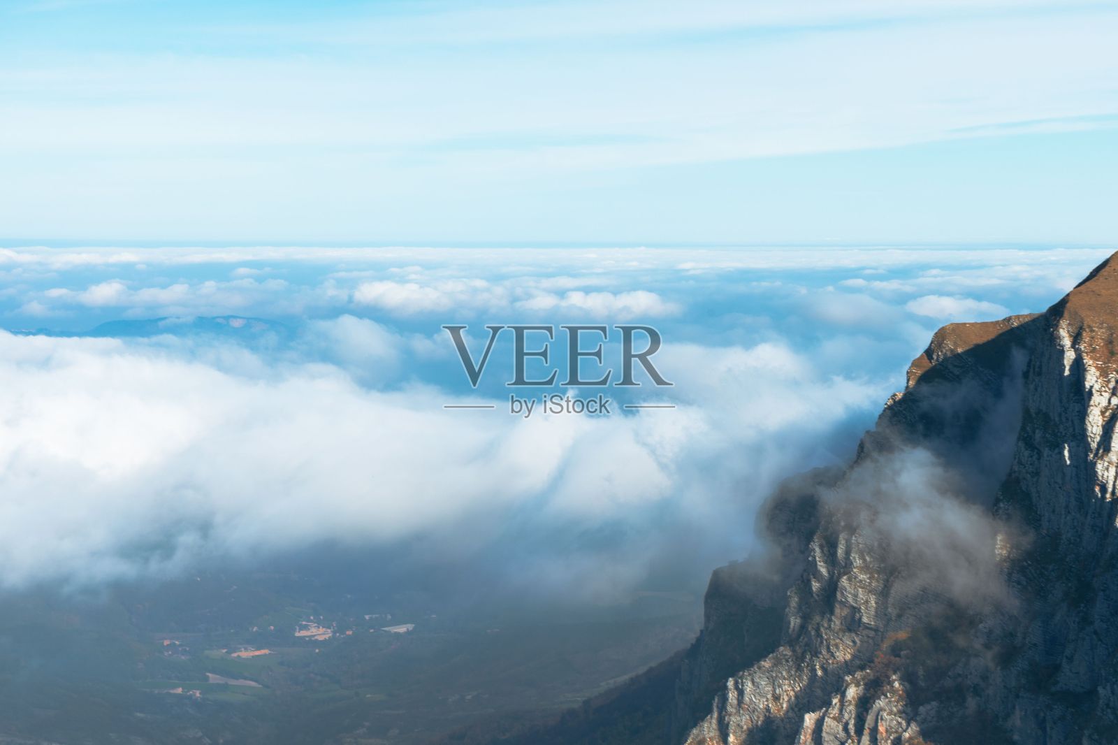 一块岩石，上面有云，山上有一个人照片摄影图片