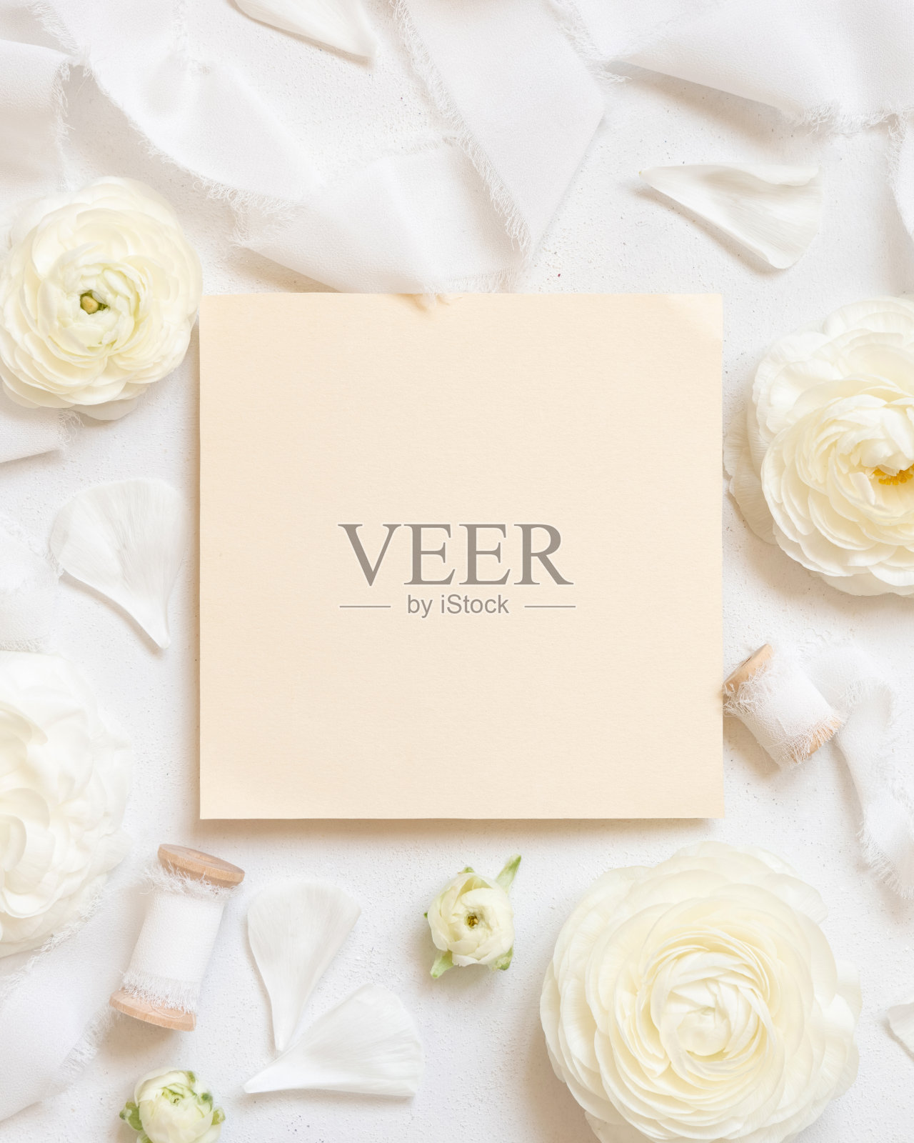 方空白卡附近的奶油玫瑰和白色丝带顶视图，婚礼的模型照片摄影图片