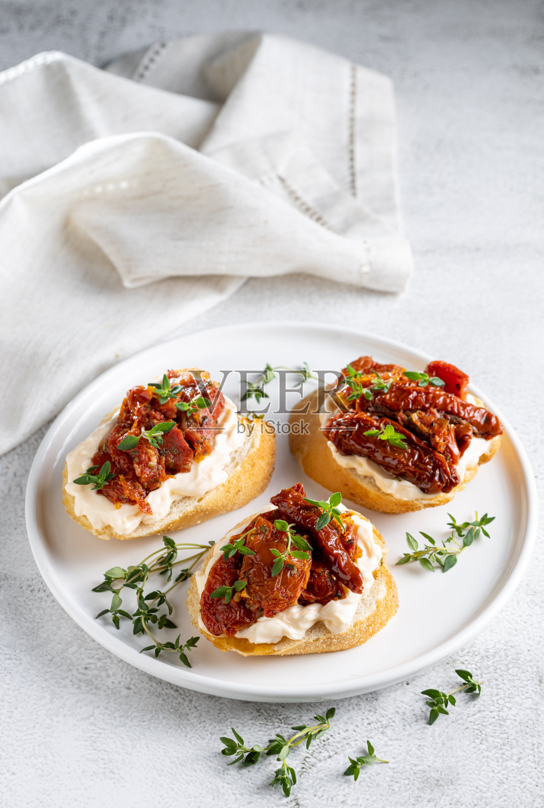 意式烤面包配番茄干，奶油奶酪和青菜。照片摄影图片