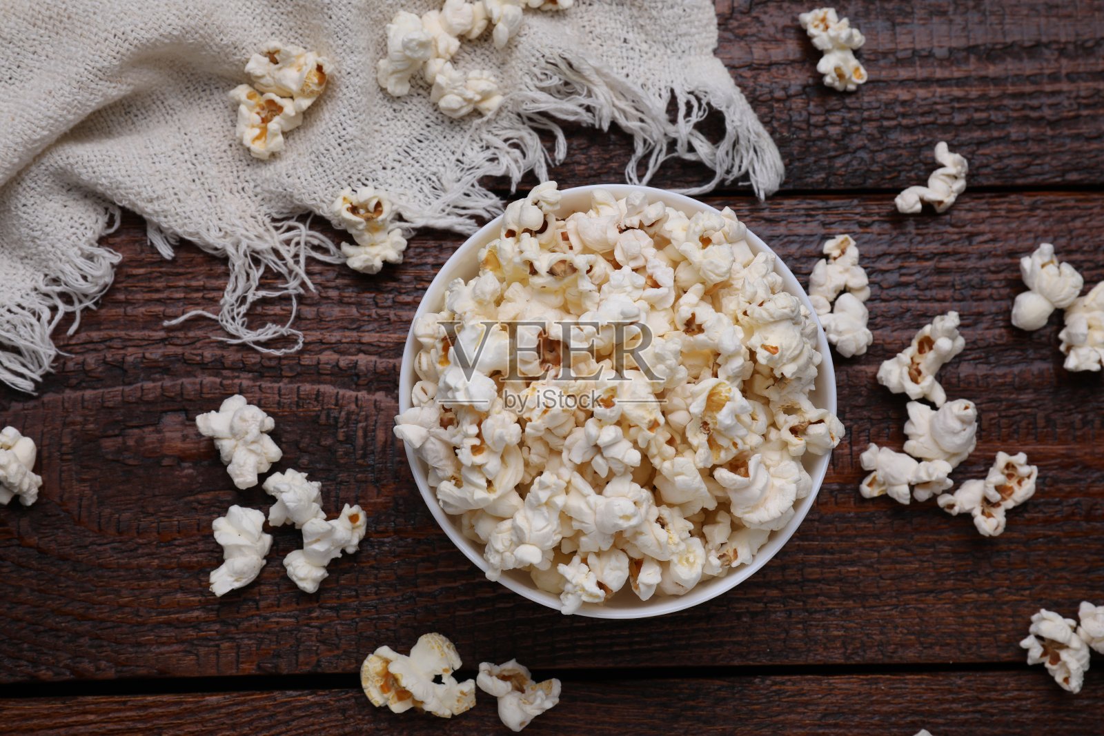 一碗美味的爆米花放在木桌上，平躺着照片摄影图片