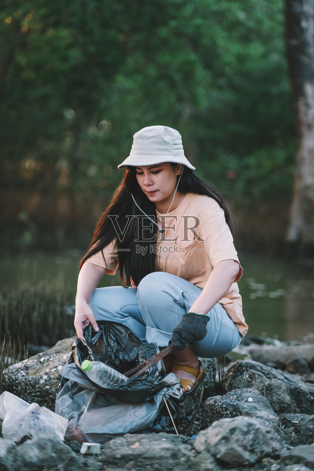 亚洲女性环境保护志愿者帮助保持和清理海滩和红树林地区的塑料和泡沫垃圾。世界环境日志愿服务。照片摄影图片