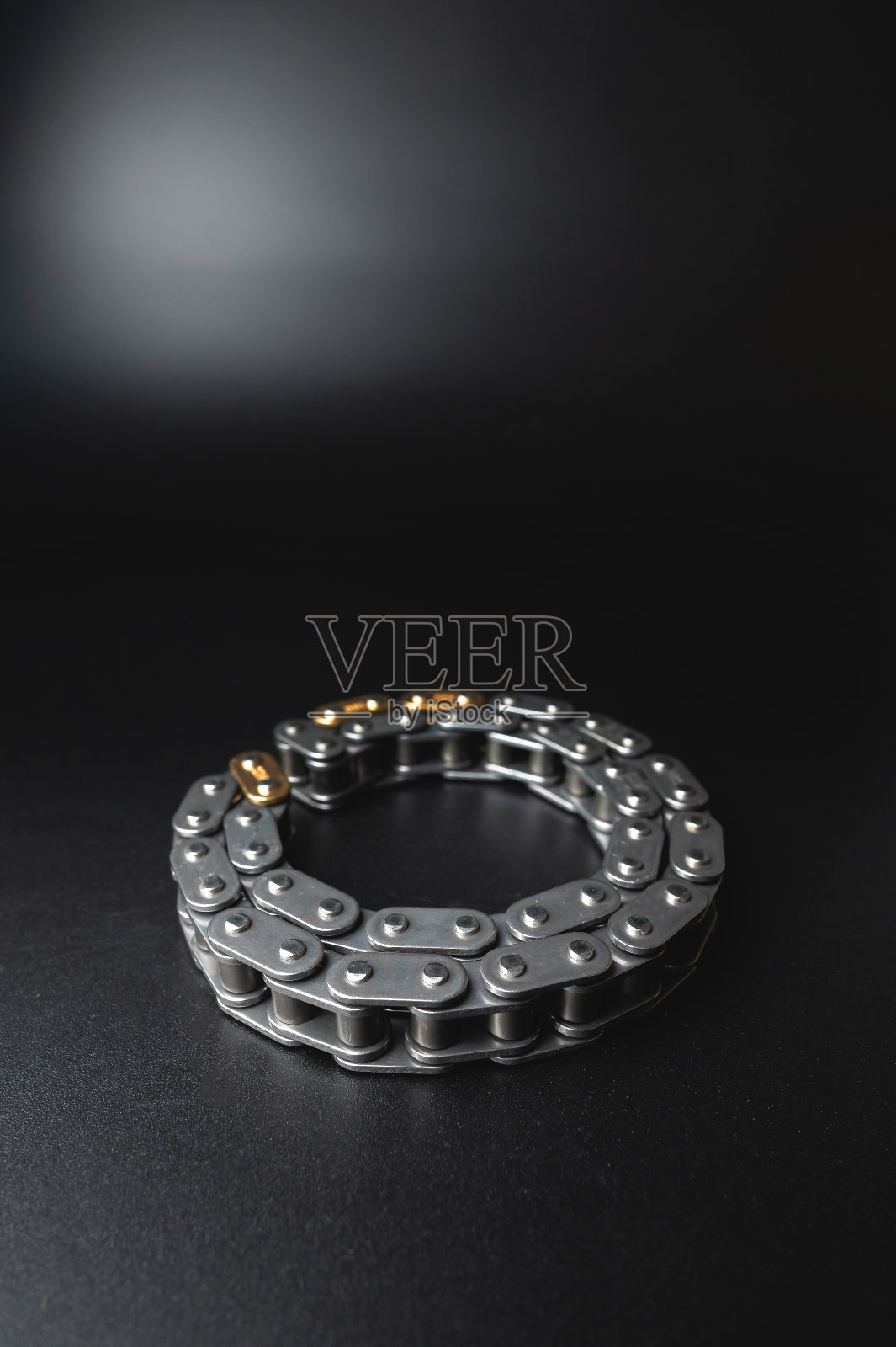黑色背景下内燃机正时链的选择聚焦。备件照片摄影图片
