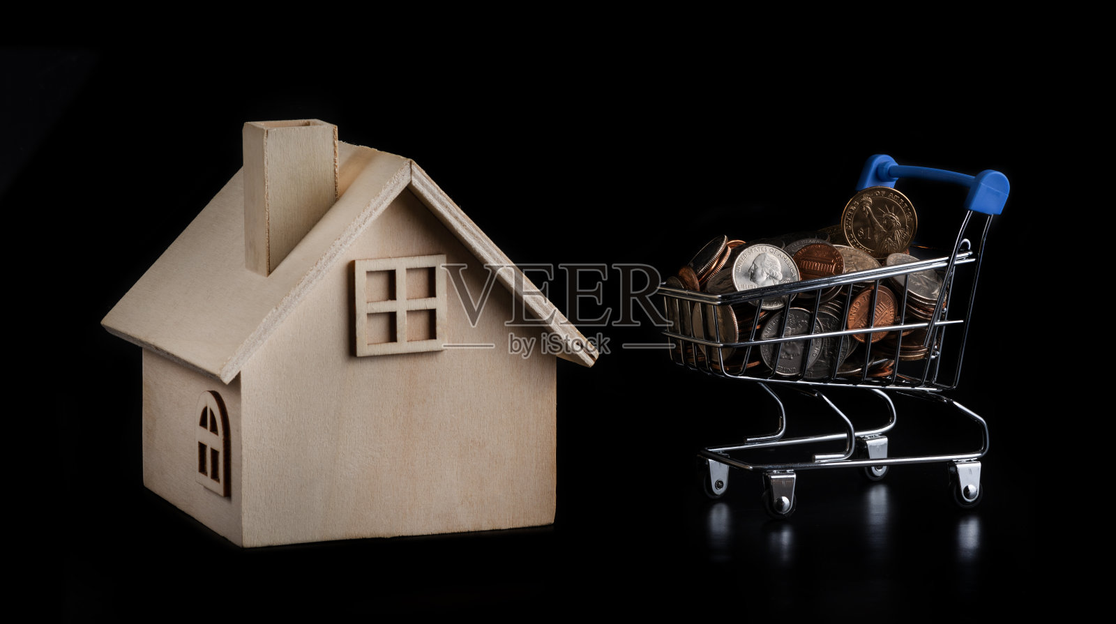 超市里的购物车，上面有美国的各种硬币，黑色背景上有一个象征性的木坝照片摄影图片