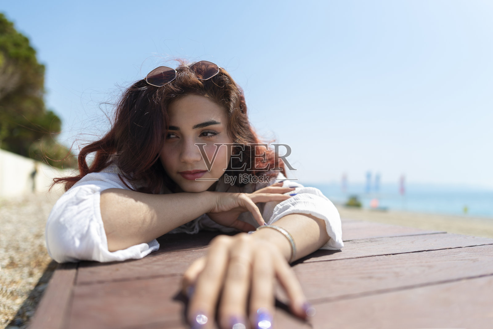 在海滩上晒日光浴的女人。照片摄影图片