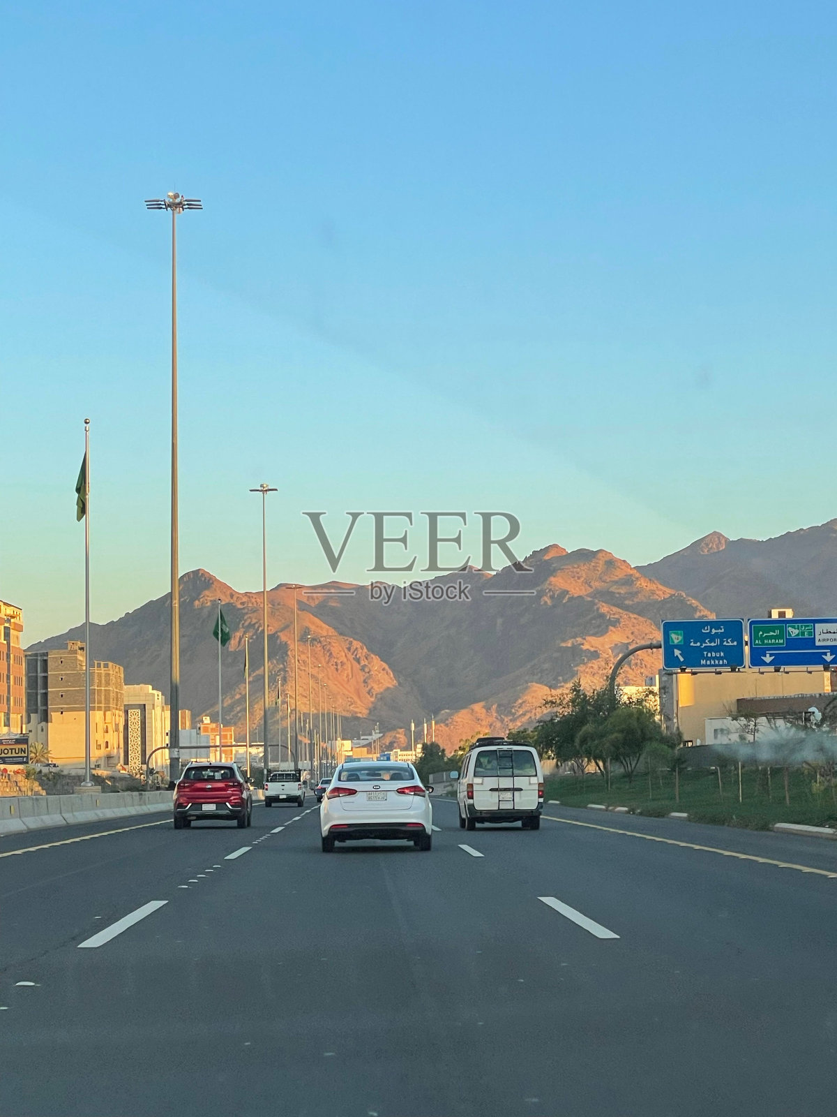 在沙特阿拉伯，汽车行驶在点缀着高耸山脉的风景优美的高速公路上照片摄影图片